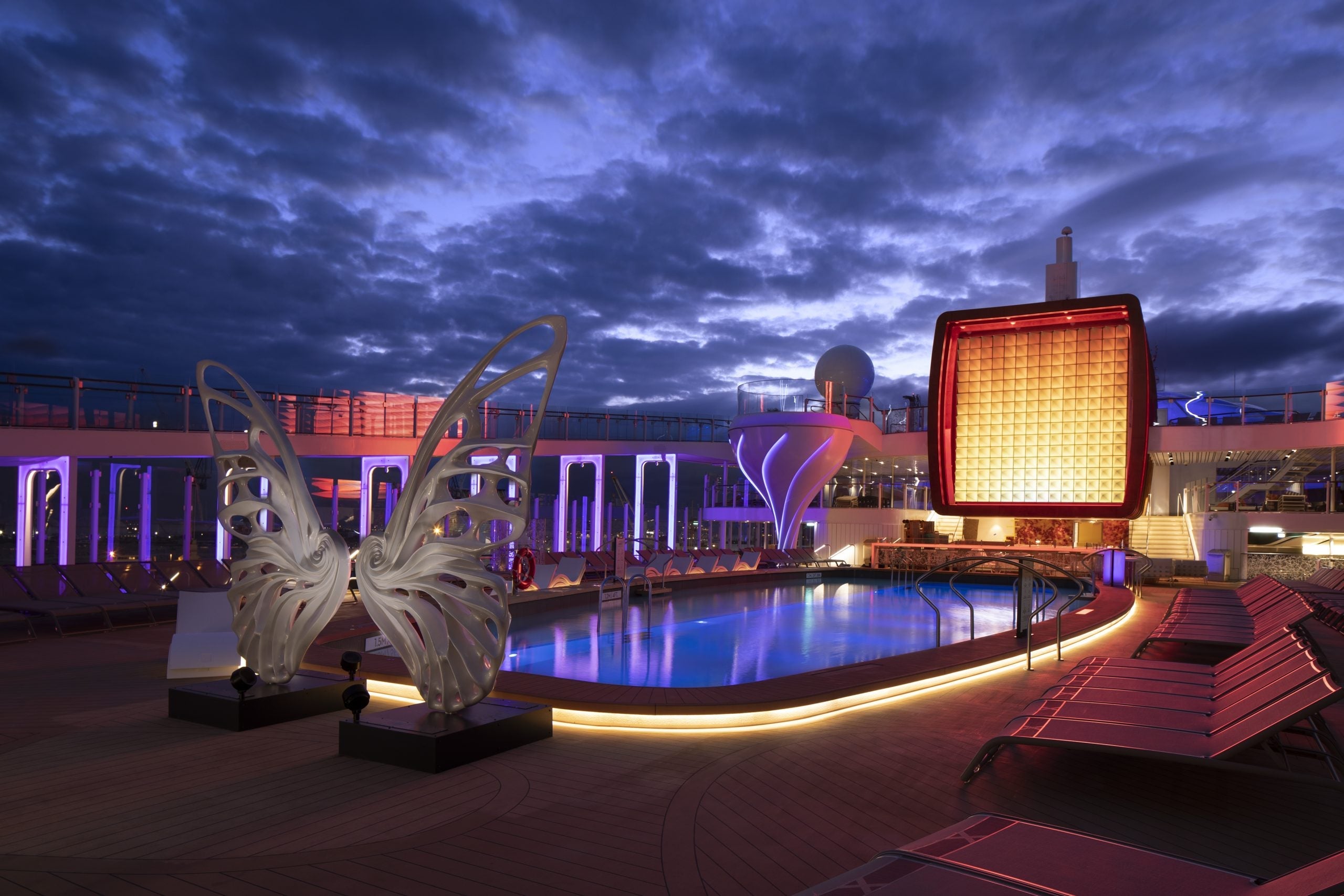 The serene pool deck on Celebrity Edge at twilight. Don’t expect waterslides and bumper car pavilions on this ship.