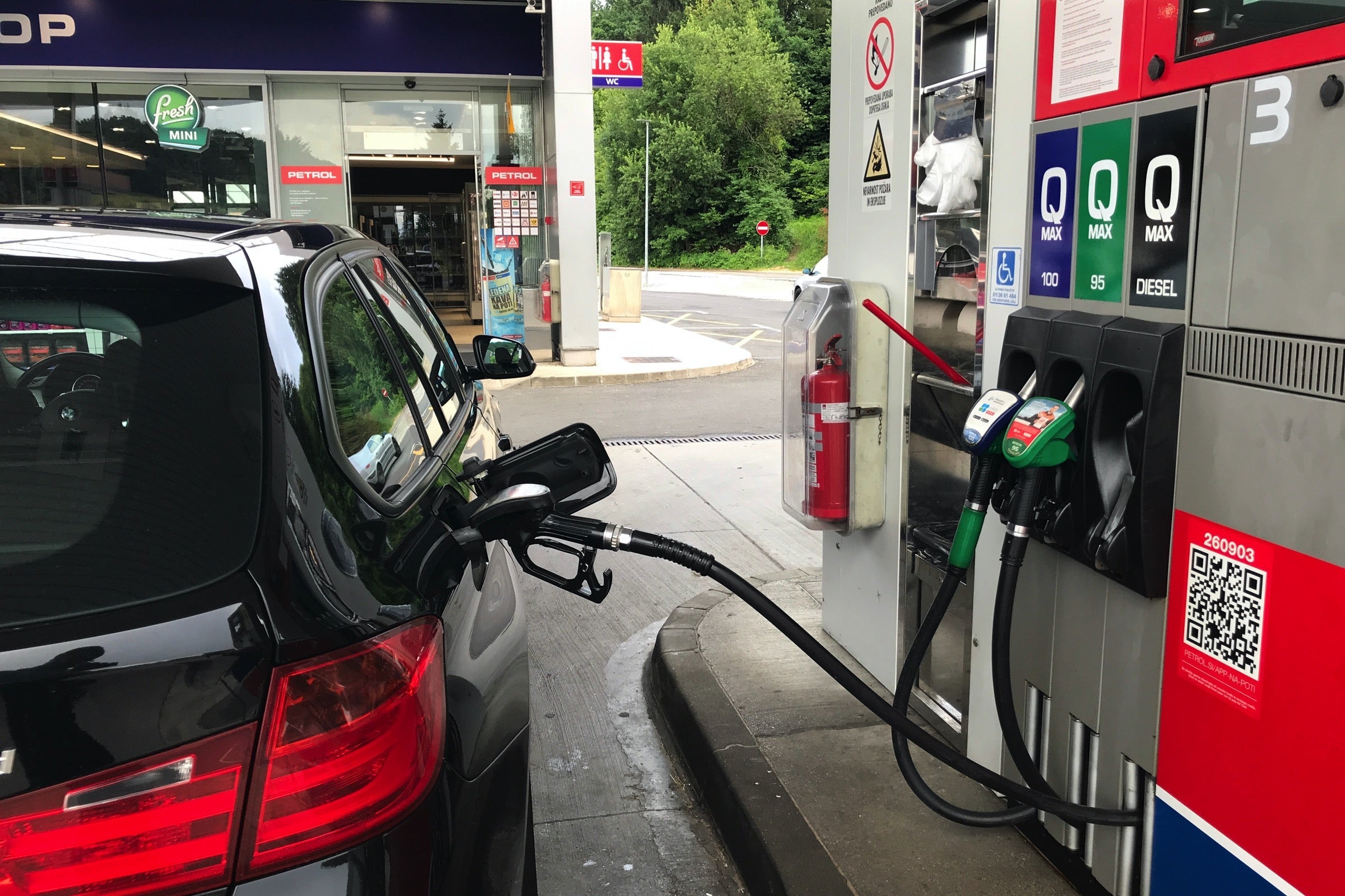 Black BMW 3 series fueling at a gas station in Slovenia