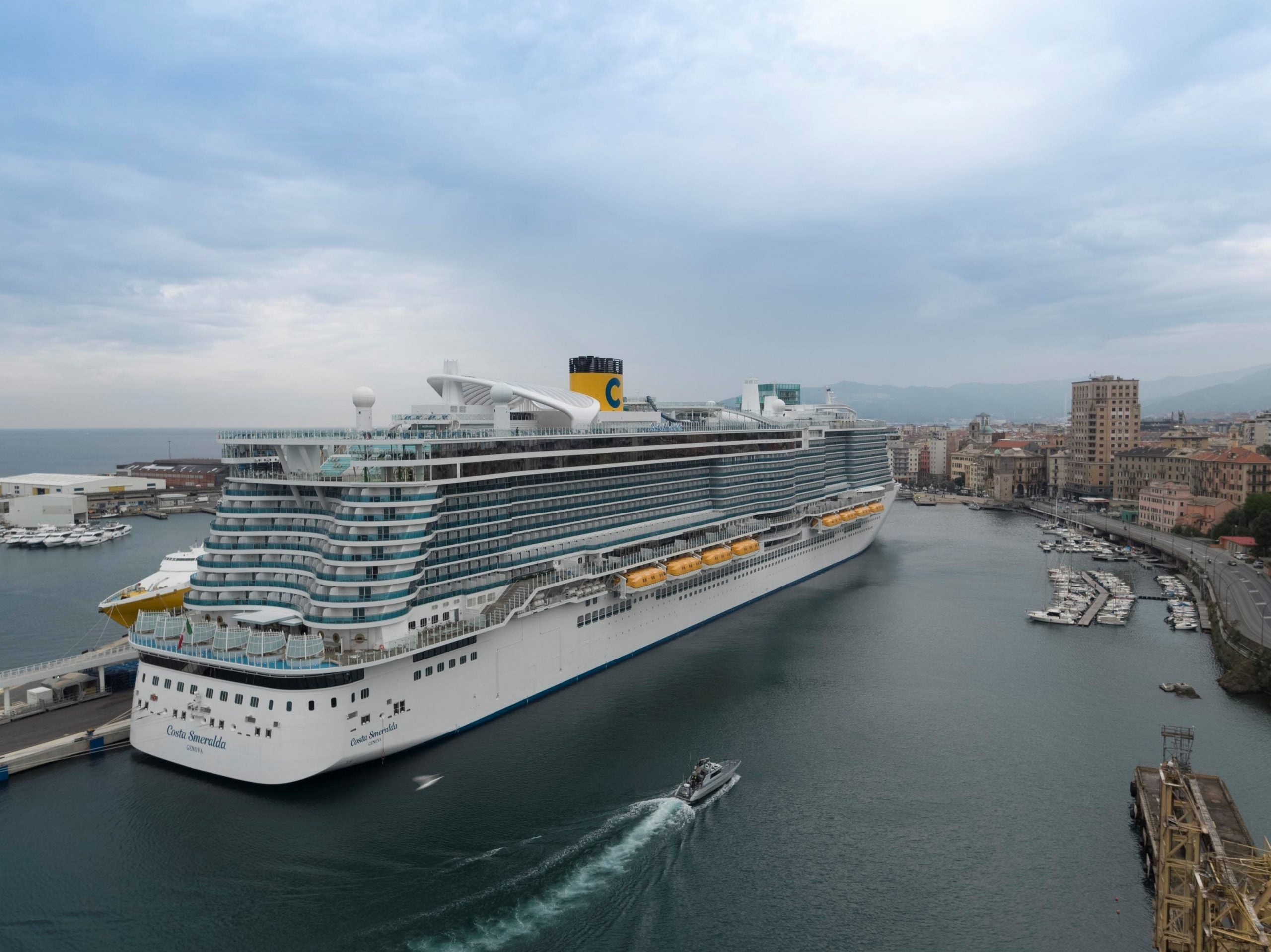 A cruise ship with a yellow funnel sailing away