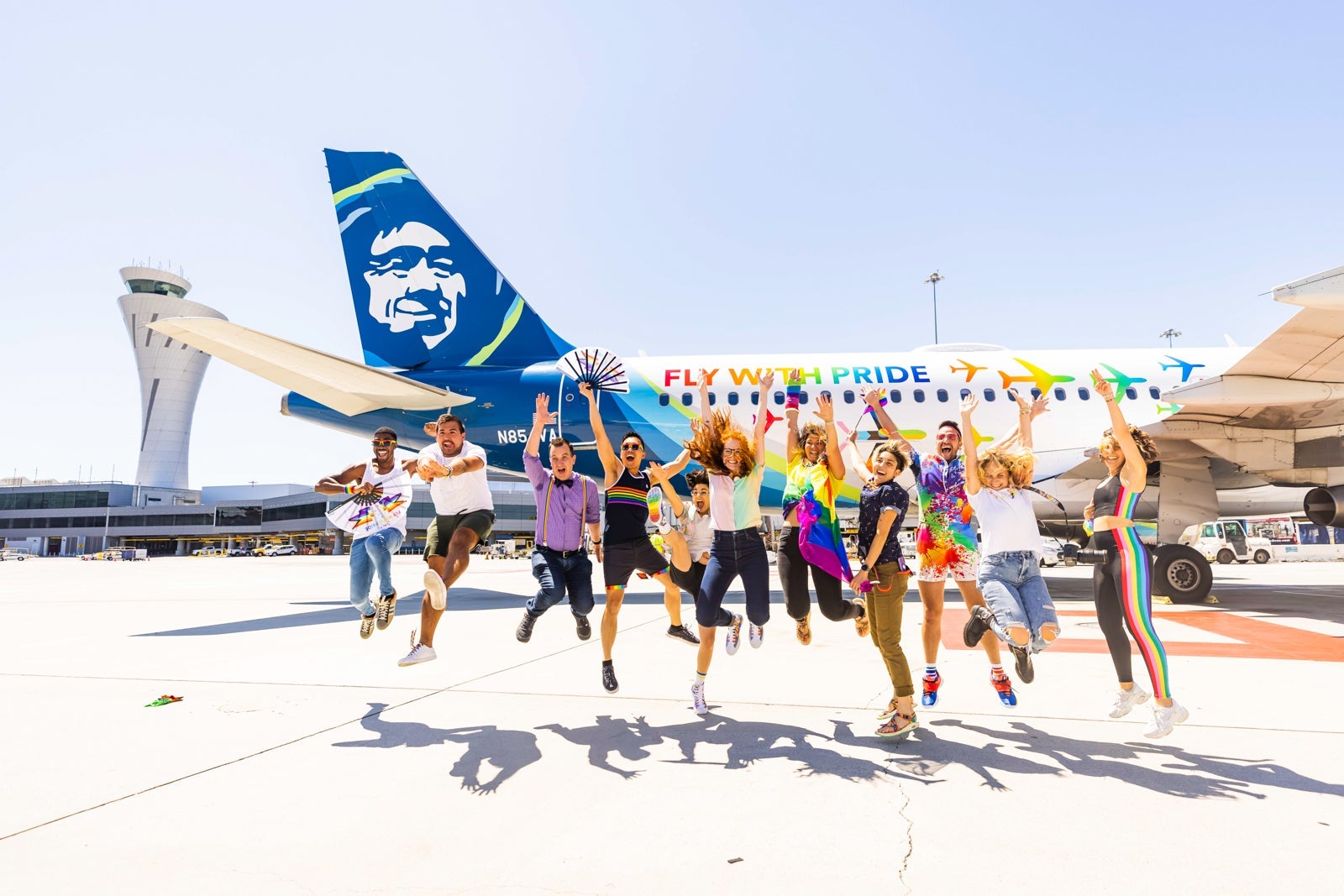 Alaska Airlines employees jump in front of plane with new livery celebrating gay pride.