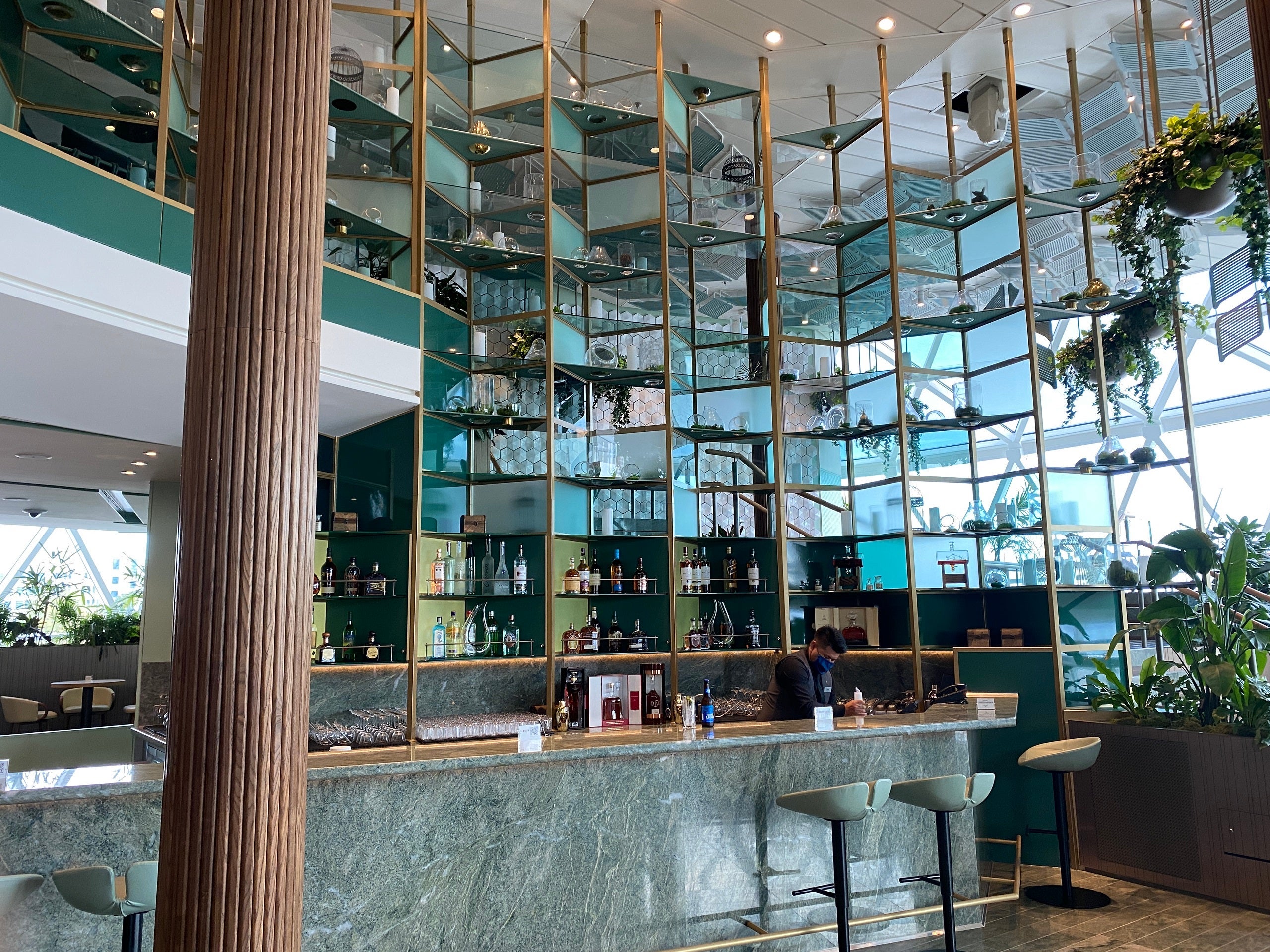 A well-lit bar with stools and a mirrored back wall