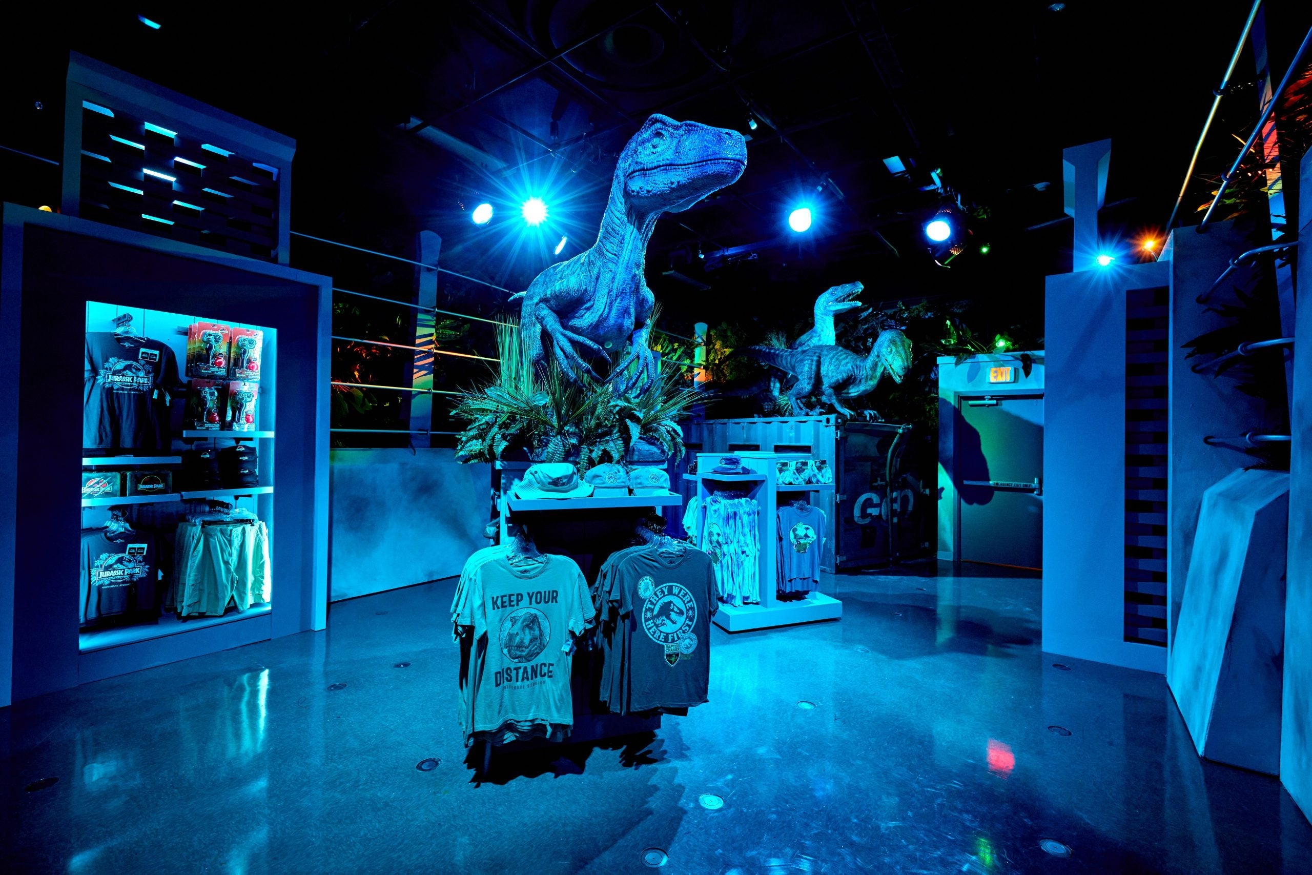 life-like statue of a velociraptor sits on top of merchandise inside the Jurassic World Velocicoaster tribute store