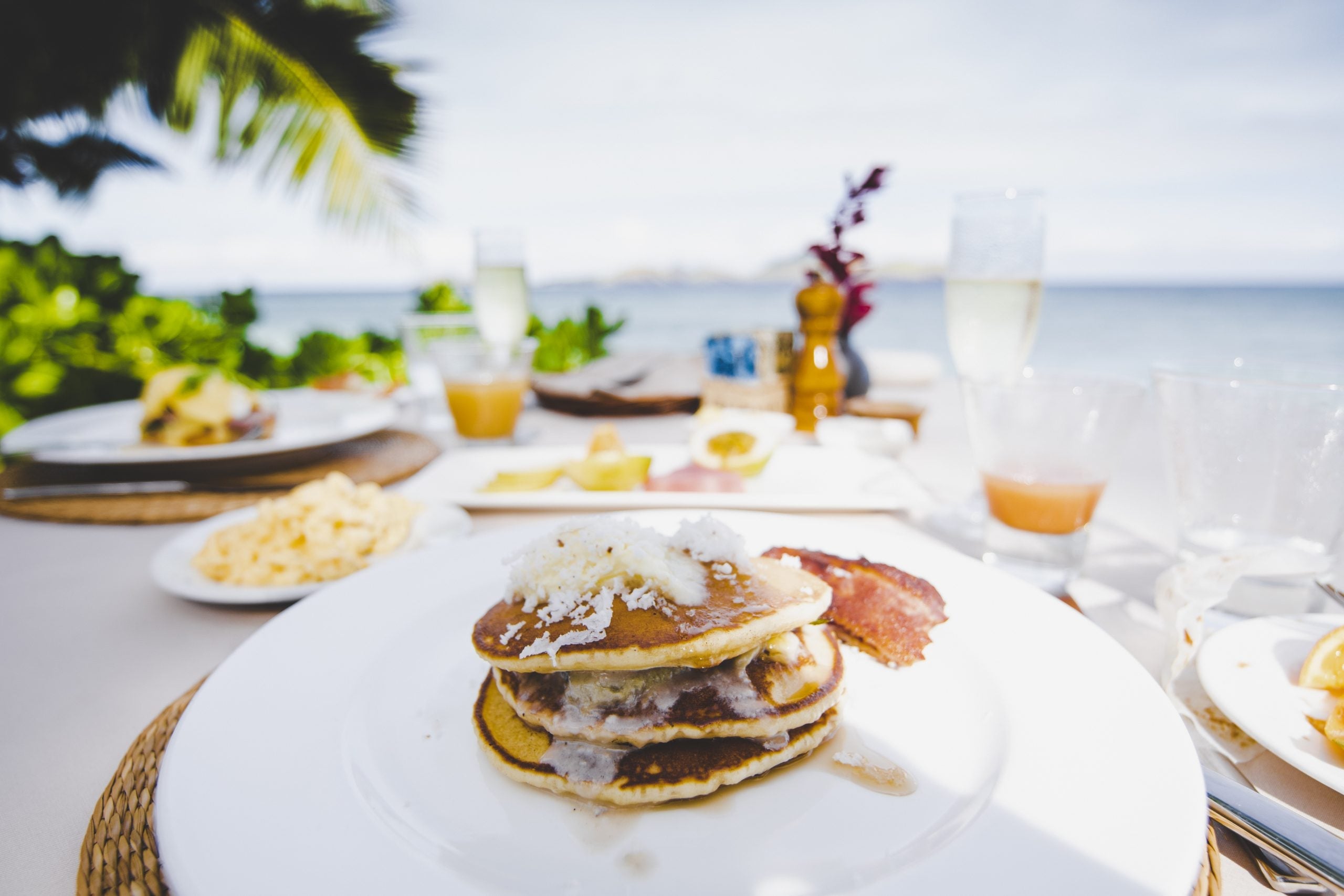 Pancakes on a plate with beach in the background