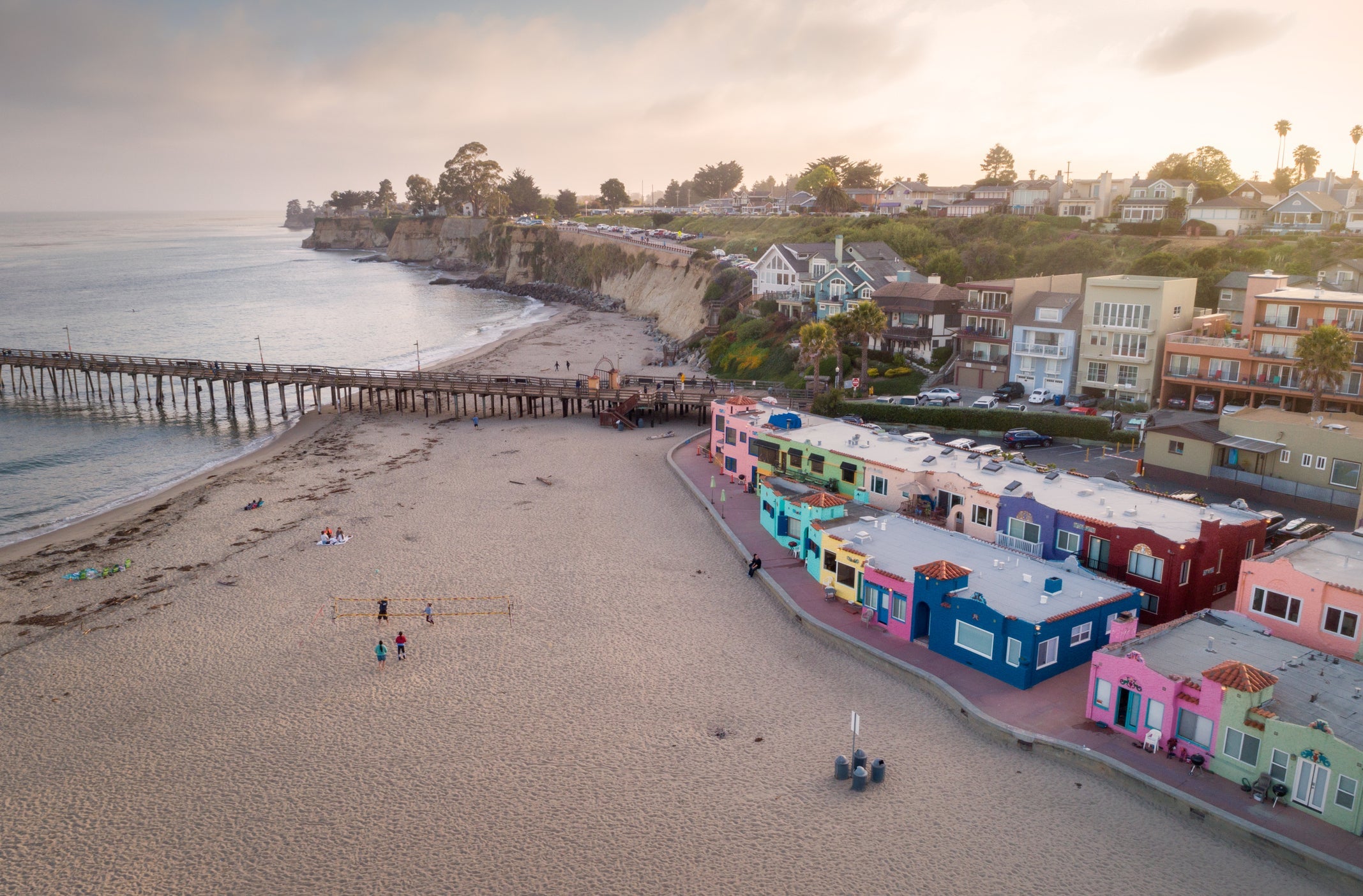 colorful buildings near a beach and pier into the ocean