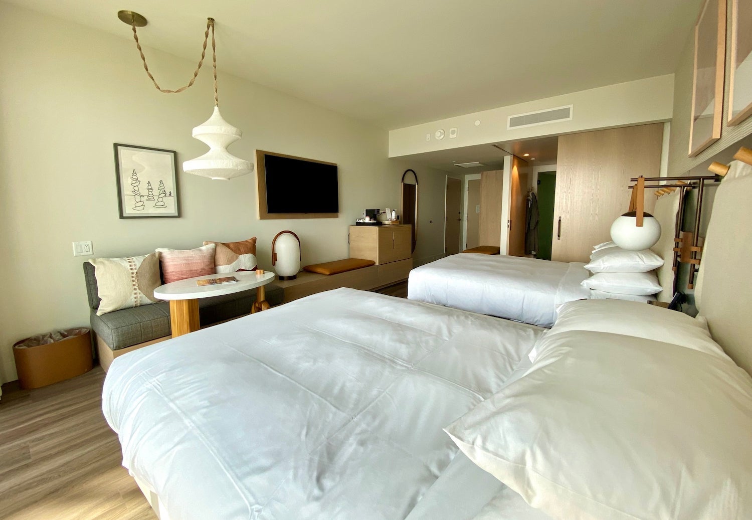 Two queen beds facing a seating area and tv