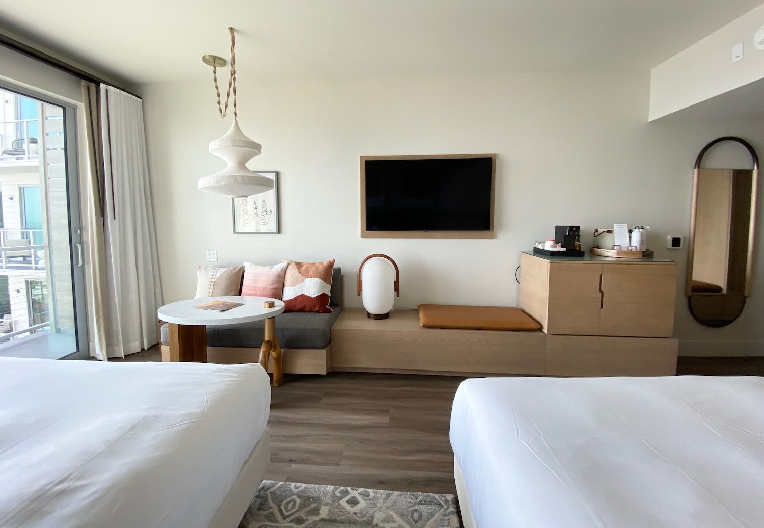 Two queen beds facing a seating area and tv