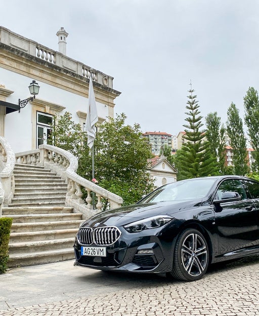 A luxury car parked out front of a staircase to a boutique hotel