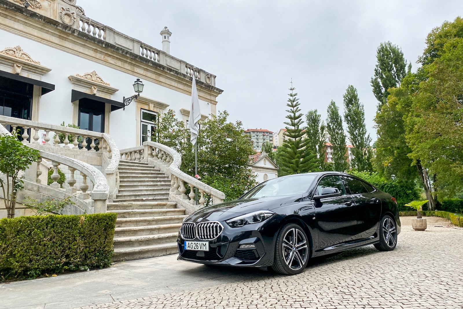 A luxury car parked out front of a staircase to a boutique hotel