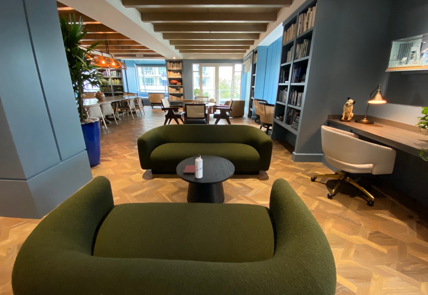 Green couches surrounded by blue bookshelves
