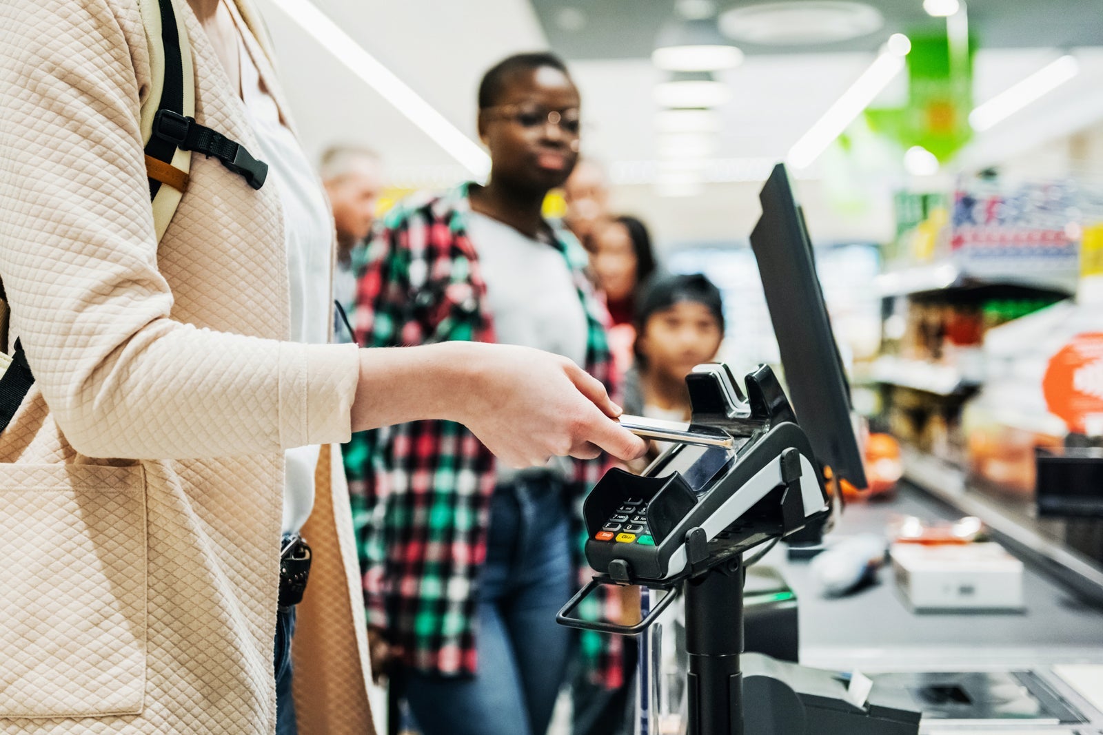 Woman Using Smartphone To Pay For Groceries