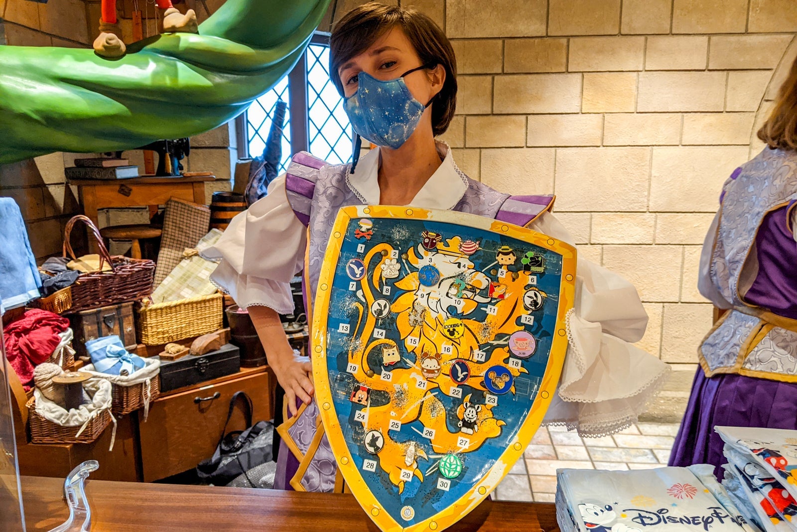 Disney staff holding a shield with pins