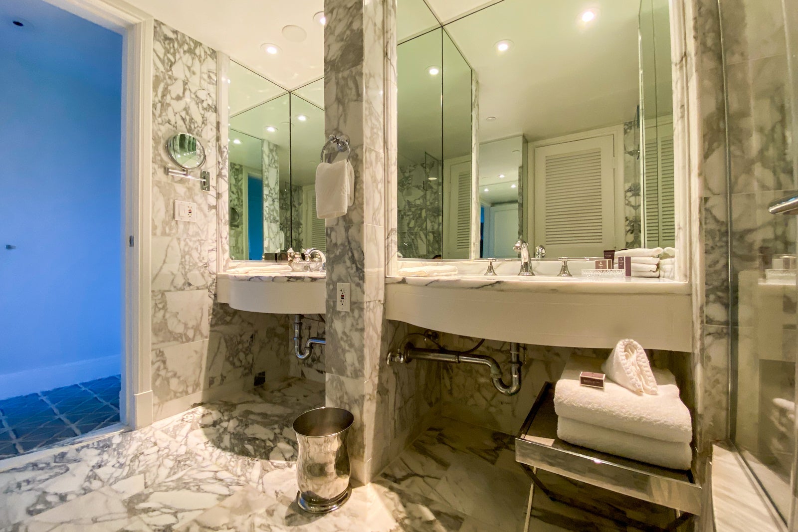 Hotel bathroom with two sinks and marble floors and backsplash