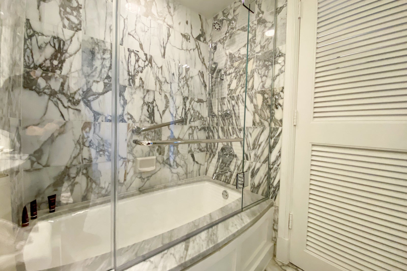 Bathtub with marble backsplash and glass divider
