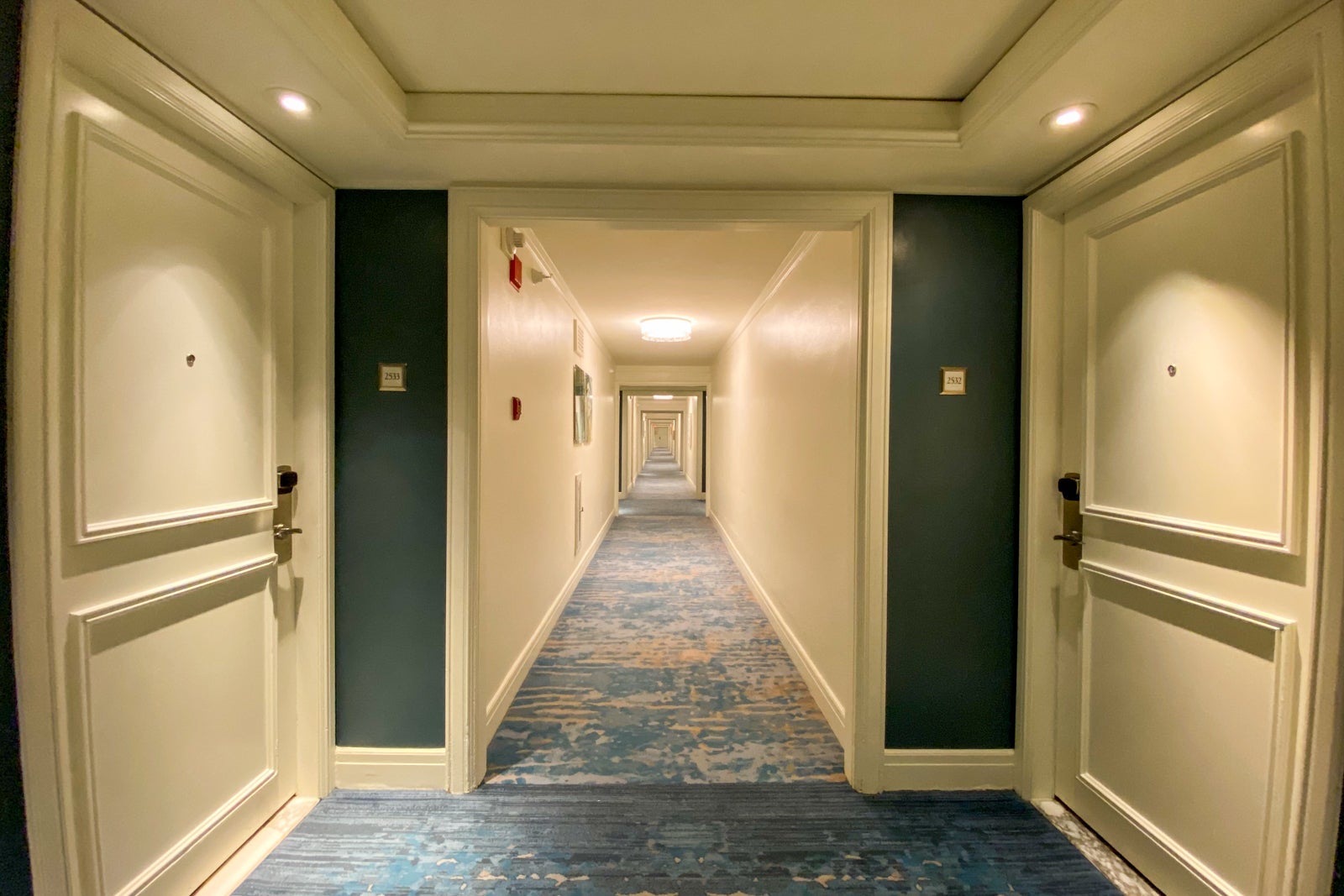 Hotel hallway with blue carpet and lighting