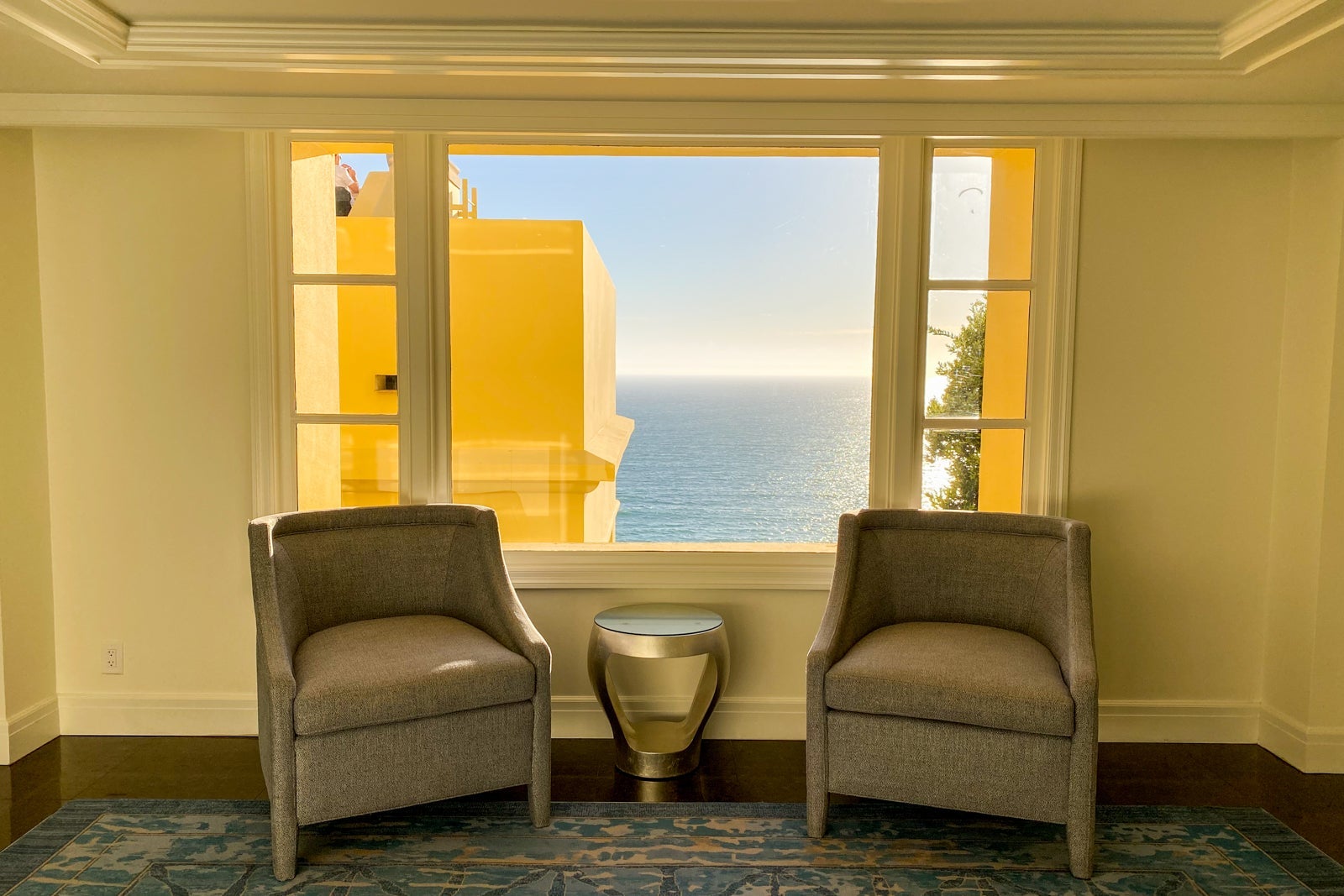 Two chairs placed in front of a window overlooking the ocean