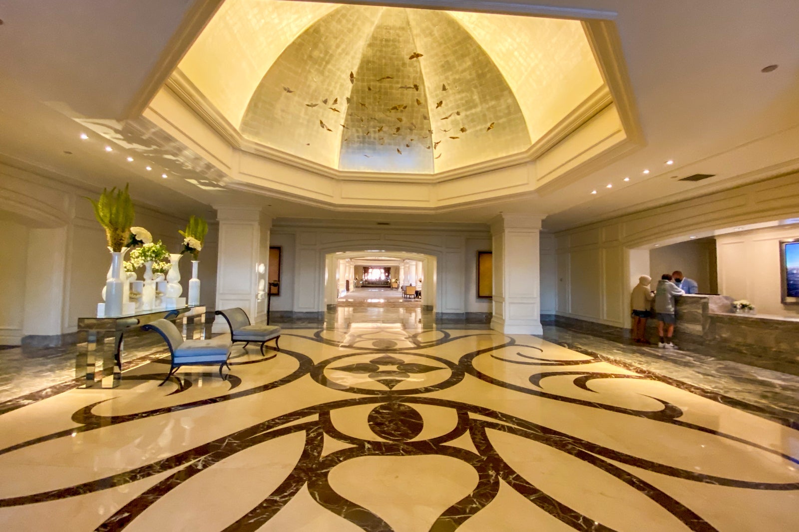 Hotel lobby with dome-shaped ceiling and marble floors featuring bornw and cream pattern