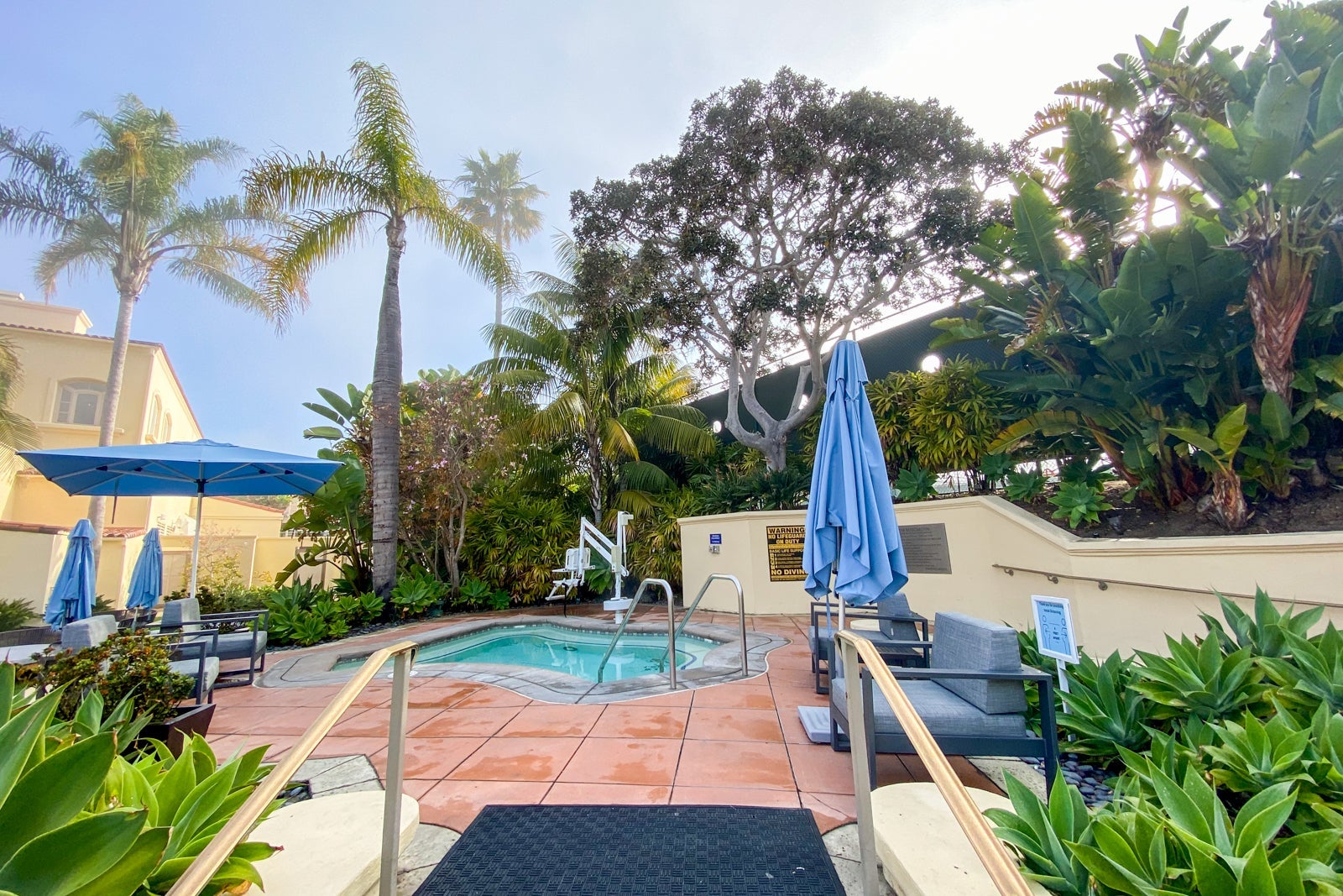 Ramp leading up to a hotel jacuzzi, with trees in the background