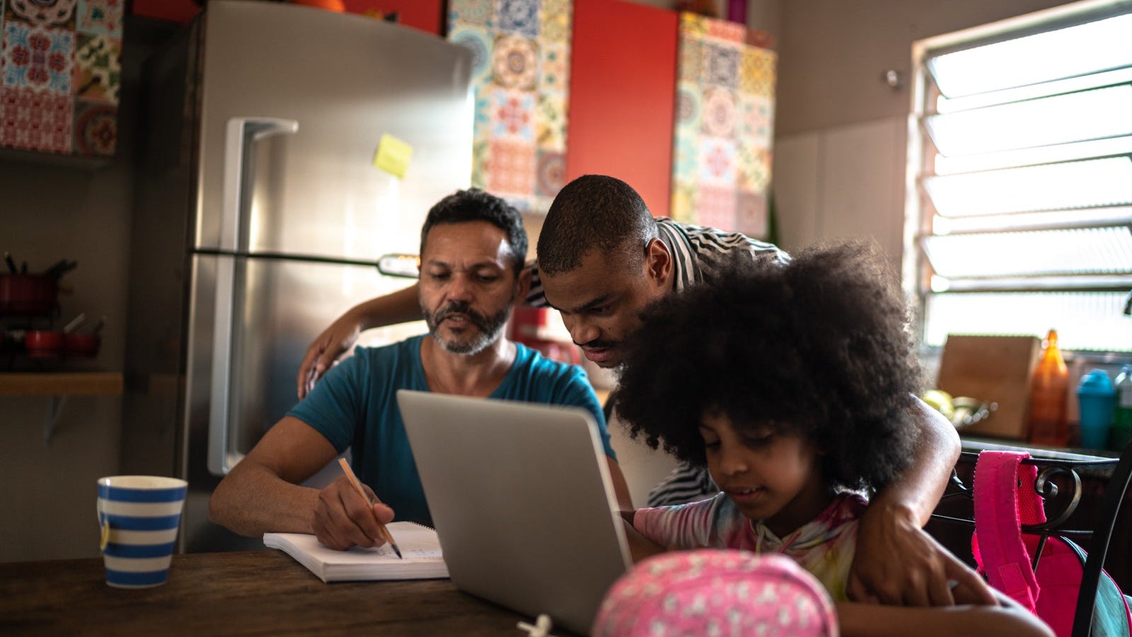 Parents helping daughter with homework at home