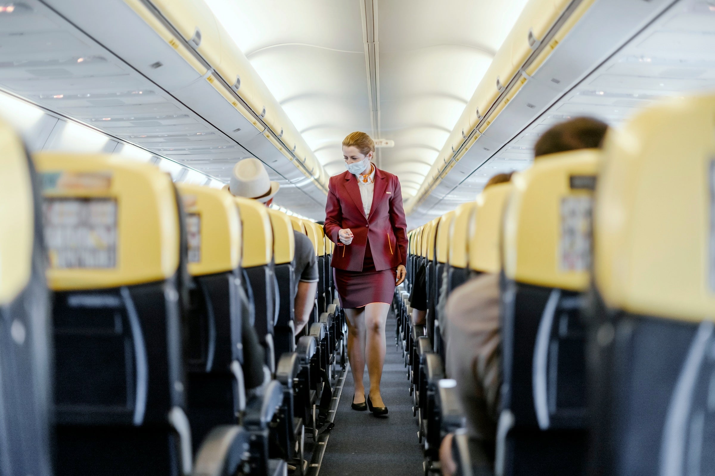 Flight attendant walking down flight aisle