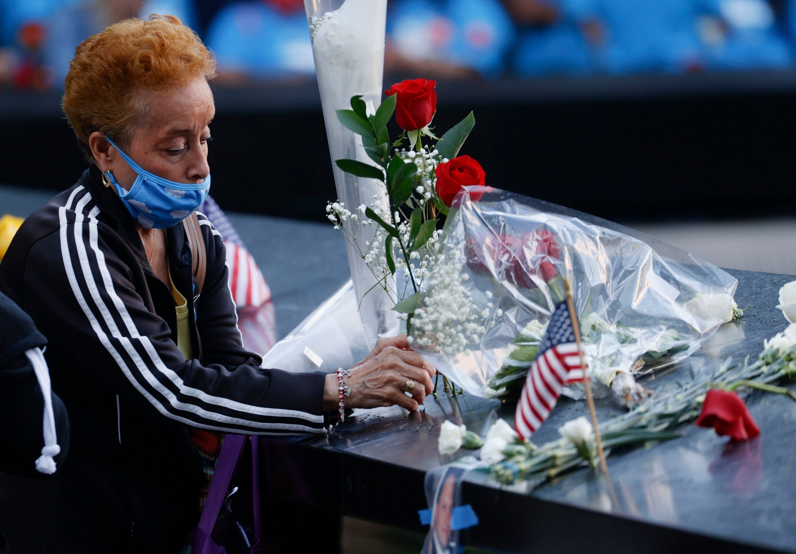 NEW YORK, NEW YORK - SEPTEMBER 11: A woman places flowers as she visits the 9/11 Memorial during a ceremony at the National September 11 Memorial & Museum commemorating the 20th anniversary of the September 11th terrorist attacks on the World Trade Center on September 11, 2021 in New York City. The nation is marking the 20th anniversary of the terror attacks of September 11, 2001, when the terrorist group al-Qaeda flew hijacked airplanes into the World Trade Center, Shanksville, PA, and the Pentagon, killing nearly 3,000 people. (Photo by Mike Segar-Pool/Getty Images)