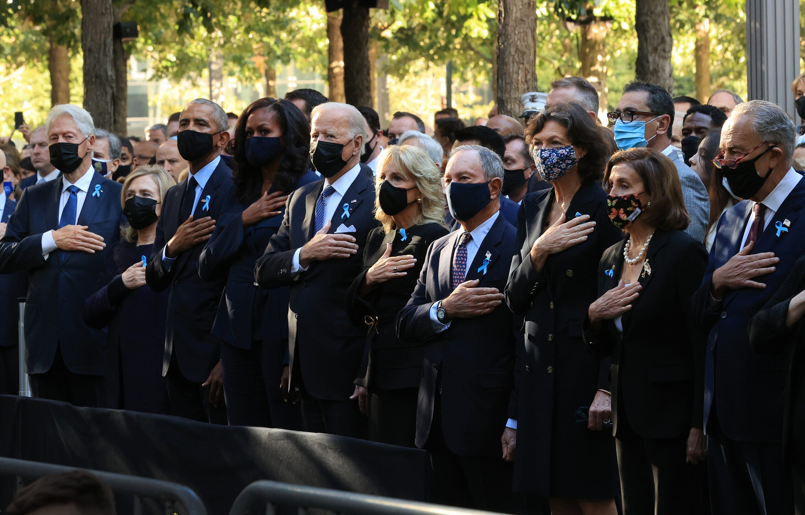 NEW YORK, NEW YORK - SEPTEMBER 11: (L-R) Former President Bill Clinton, former First Lady Hillary Clinton, former President Barack Obama, former First Lady Michelle Obama, President Joe Biden, First Lady Jill Biden, former New York City Mayor Michael Bloomberg, Bloomberg's partner Diana Taylor, Speaker of the House Nancy Pelosi (D-CA) and Senate Majority Leader Charles Schumer (D-NY) stand for the national anthem during the annual 9/11 Commemoration Ceremony at the National 9/11 Memorial and Museum on September 11, 2021 in New York City. During the ceremony six moments of silence were held, marking when each of the World Trade Center towers was struck and fell and the times corresponding to the attack on the Pentagon and the crash of Flight 93. The nation is marking the 20th anniversary of the terror attacks of September 11, 2001, when the terrorist group al-Qaeda flew hijacked airplanes into the World Trade Center, Shanksville, PA and the Pentagon, killing nearly 3,000 people. (Photo by Chip Somodevilla/Getty Images)