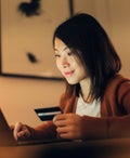 Young Woman Shopping Online With Laptop And Credit Card At Home