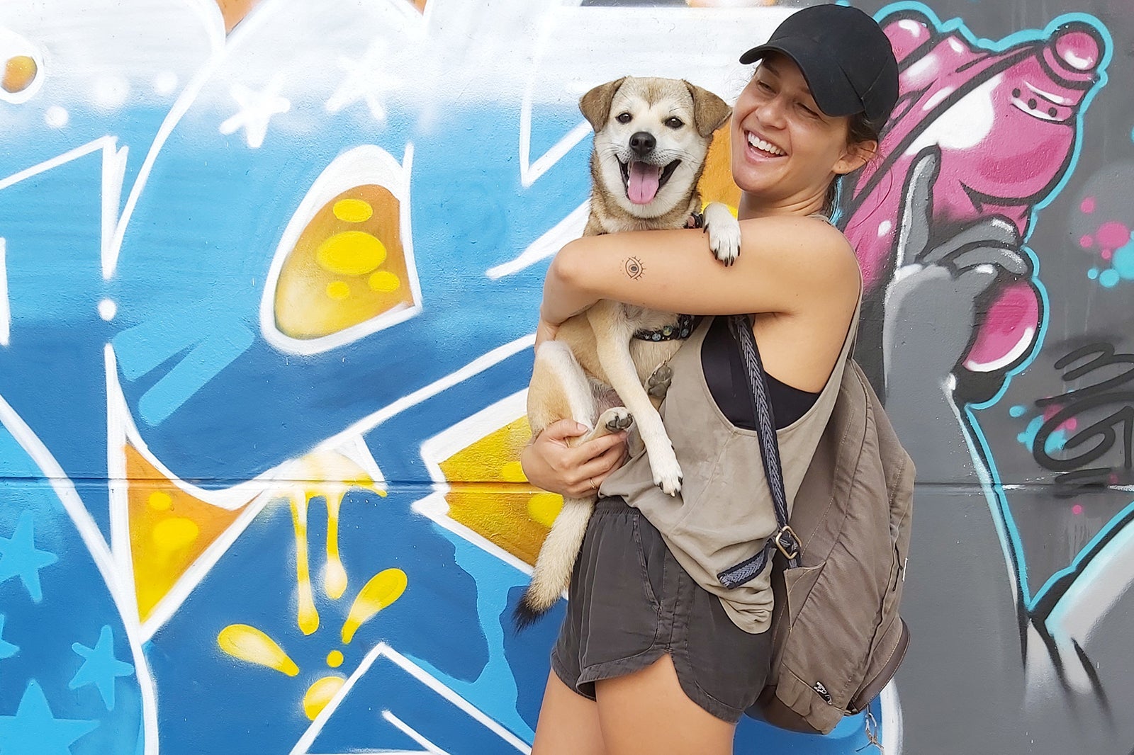 A woman holding a smiling dog