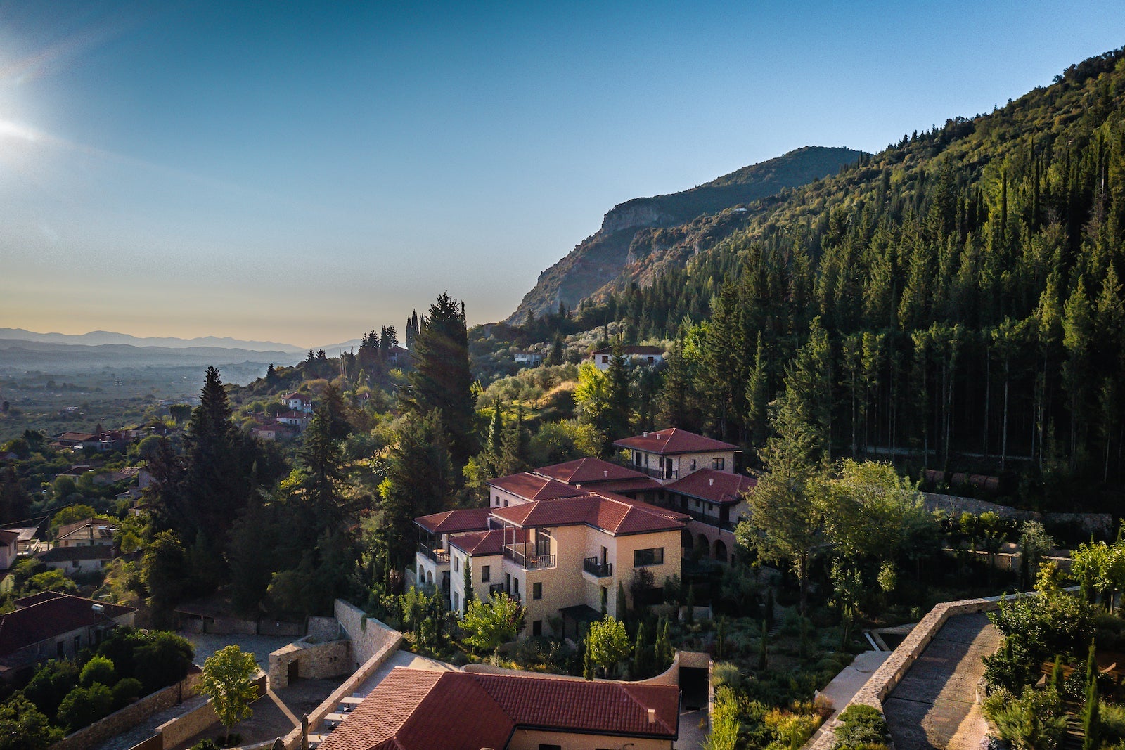 mountainside resort with red roof and tall, green trees