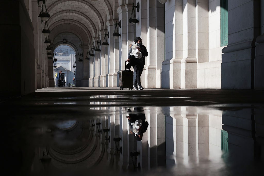 Traveler walks with carry-on luggage inside Union Station