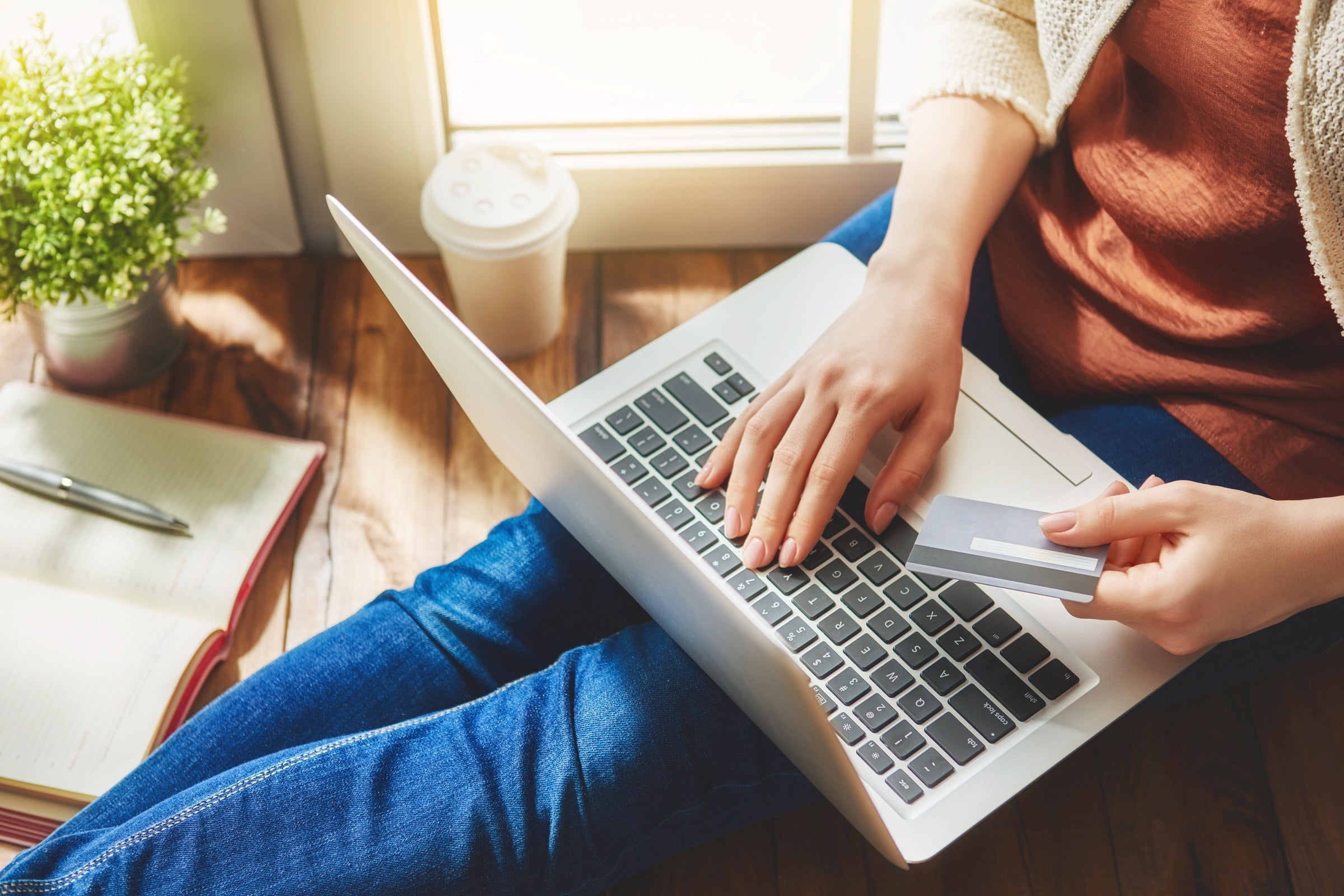 Person holding a laptop and credit card