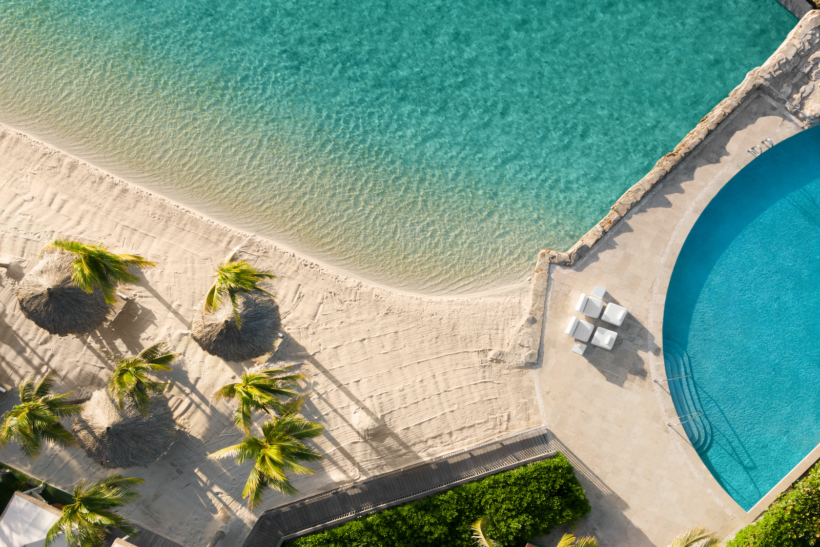 Aerial photo of sand-bottom infinity pool and beach