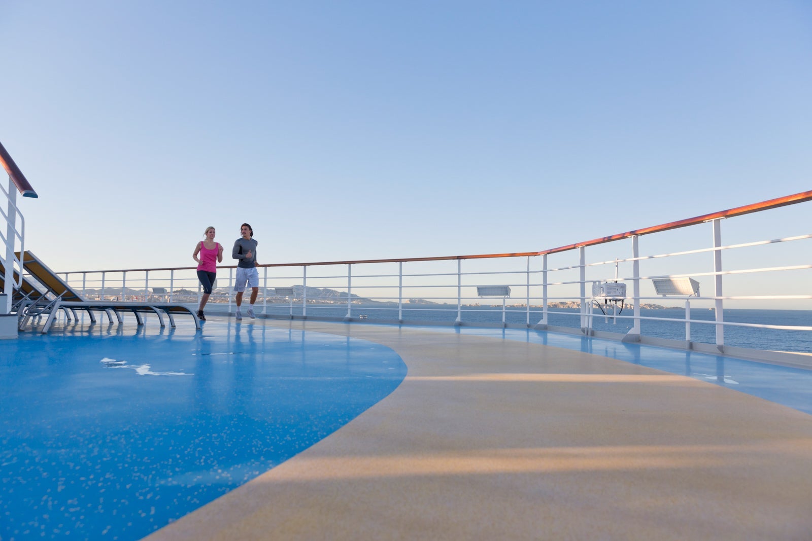 Young couple is jogging around the shipdeck of a cruise ship, Mediterranean Sea