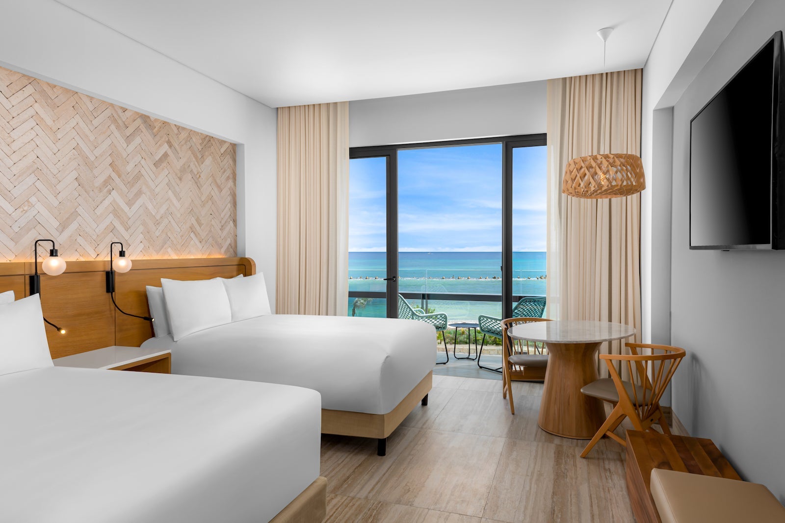 two beds in hotel room overlooking the ocean