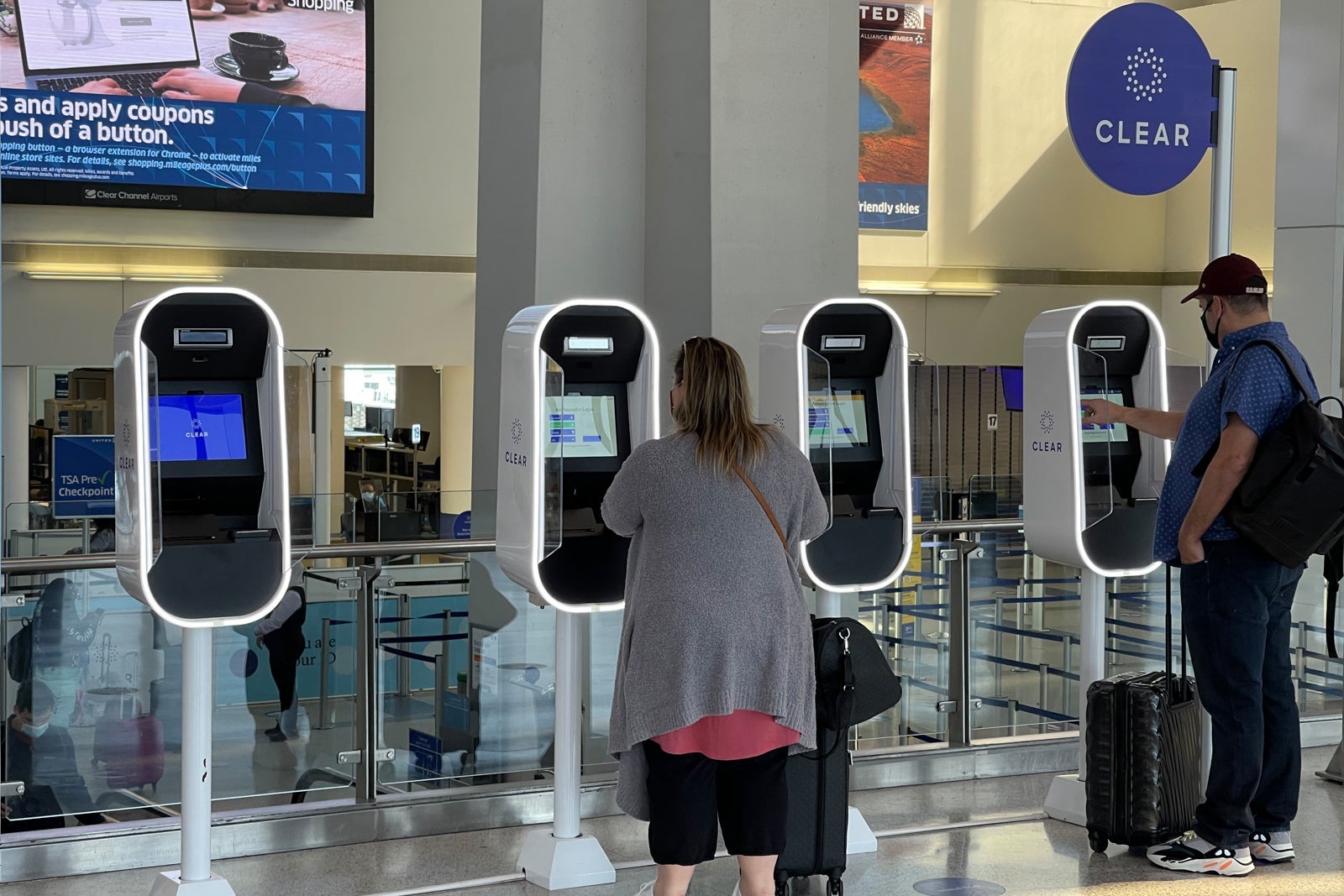 people use Clear security machines at an airport checkpoint