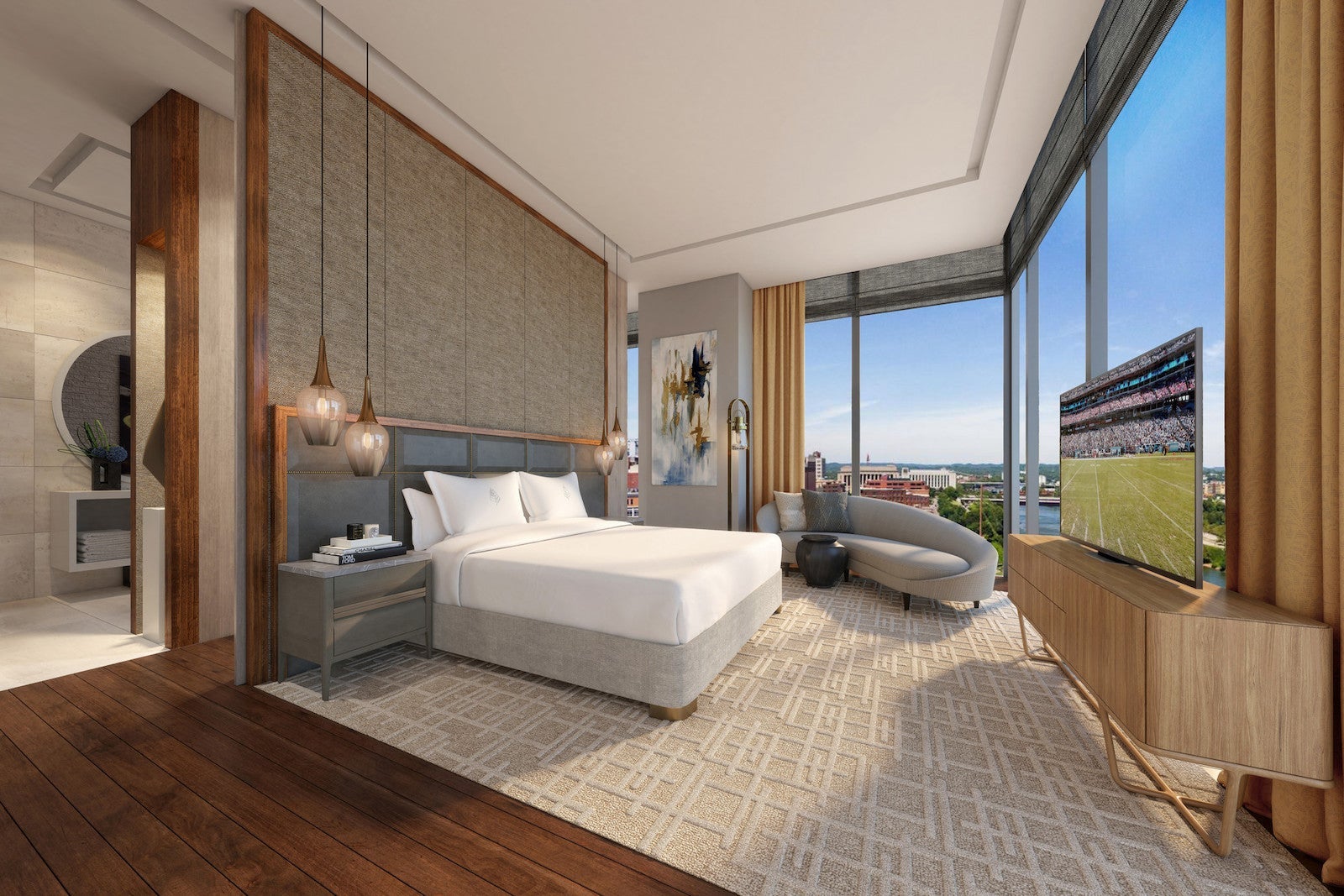 large hotel room with couch, bed and tv