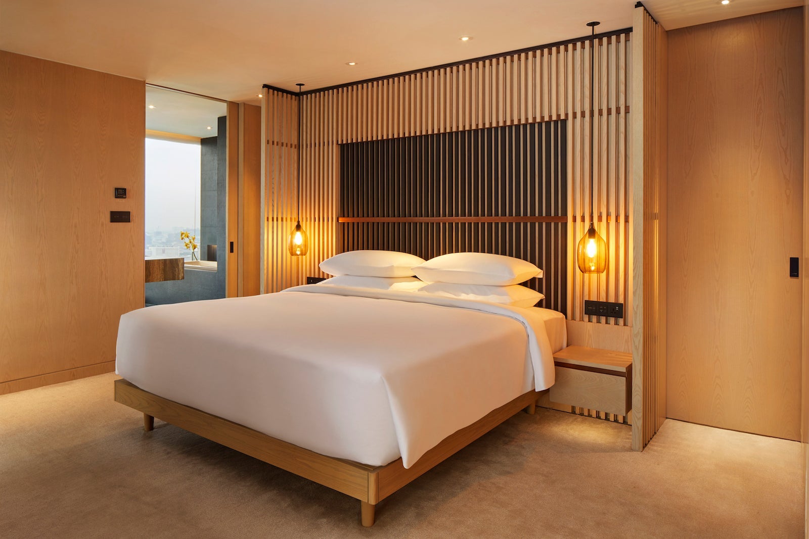 large bed against wall with wooden art display