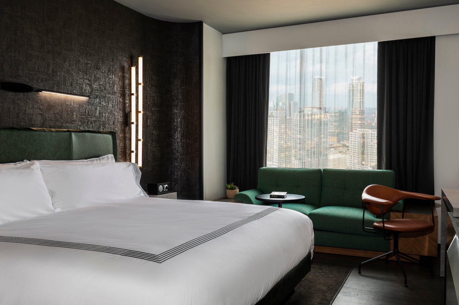 hotel room with green couch and city view