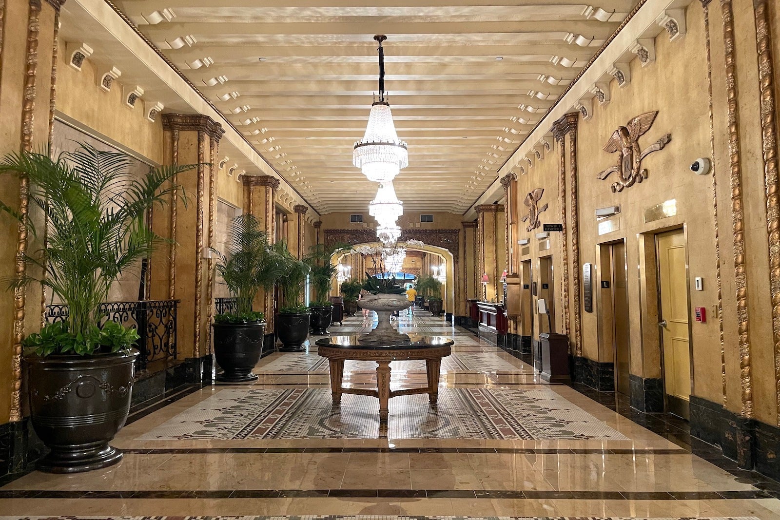 long hotel lobby with gold design and table