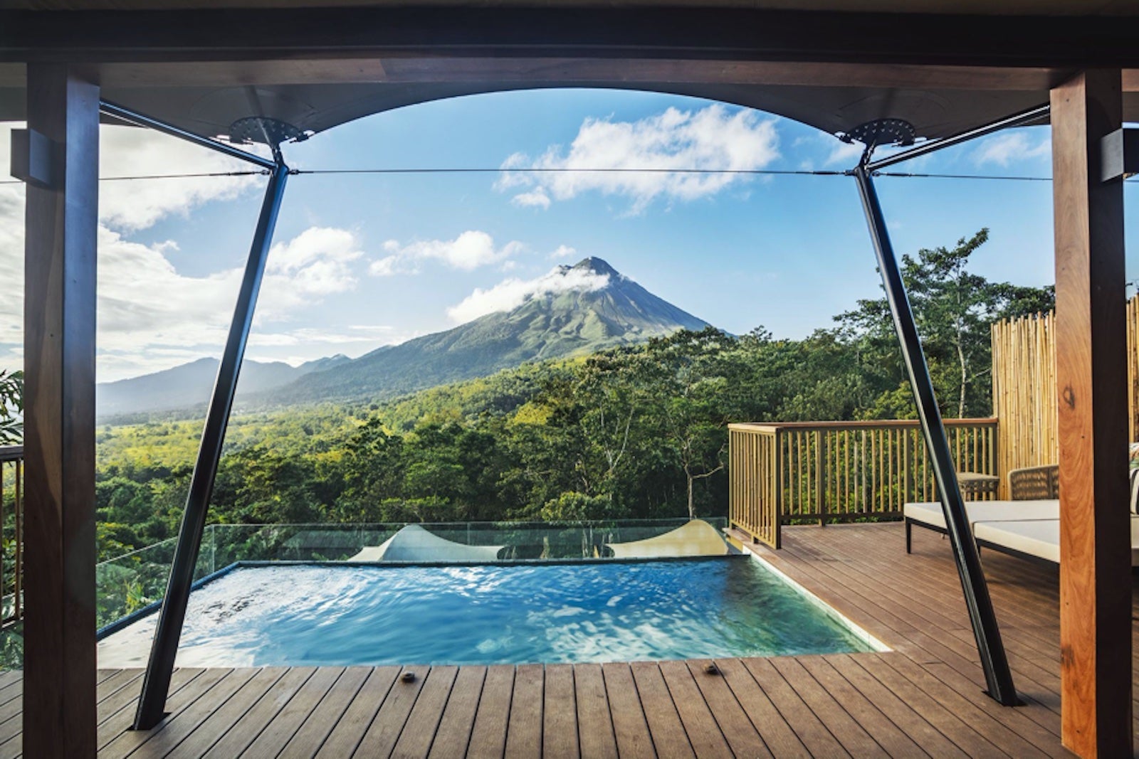 outdoor plunge pool on wooden deck overlooking lush green mountain