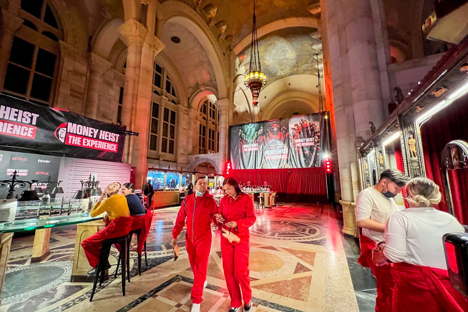 People milling about the bar and photo areas at the Money Heist experience in NYC