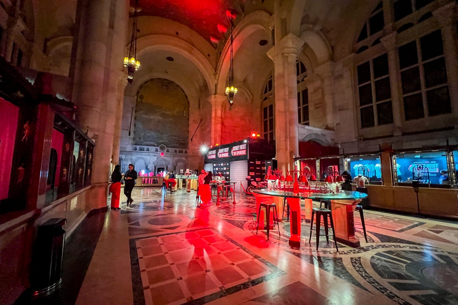 People milling about the bar and photo areas at the Money Heist experience in NYC