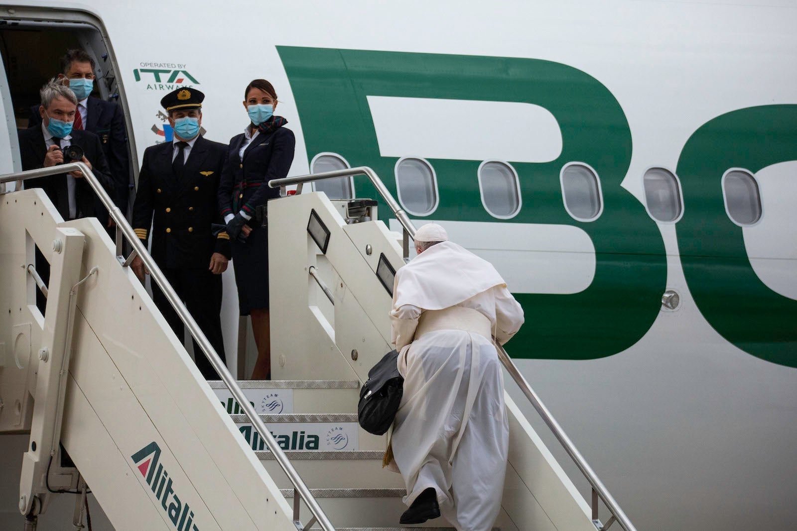 ROME, ITALY - 2021/12/02: Pope Francis seen climbing the steps of the plane, during the event. Pope Francis left for the Apostolic Journey to Cyprus and Greece from the International Leonardo Da Vinci Airport in Fiumicino, Rome. Pope Francis flies for the first time with the new Italian airline 'ITA Airways', the plane sports the livery of the new company that bears the inscription on the fuselage with the words 'Born in 2021' to celebrate the start of flight operations , which took place on 15 October 2021. (Photo by Stefano Costantino/SOPA Images/LightRocket via Getty Images)
