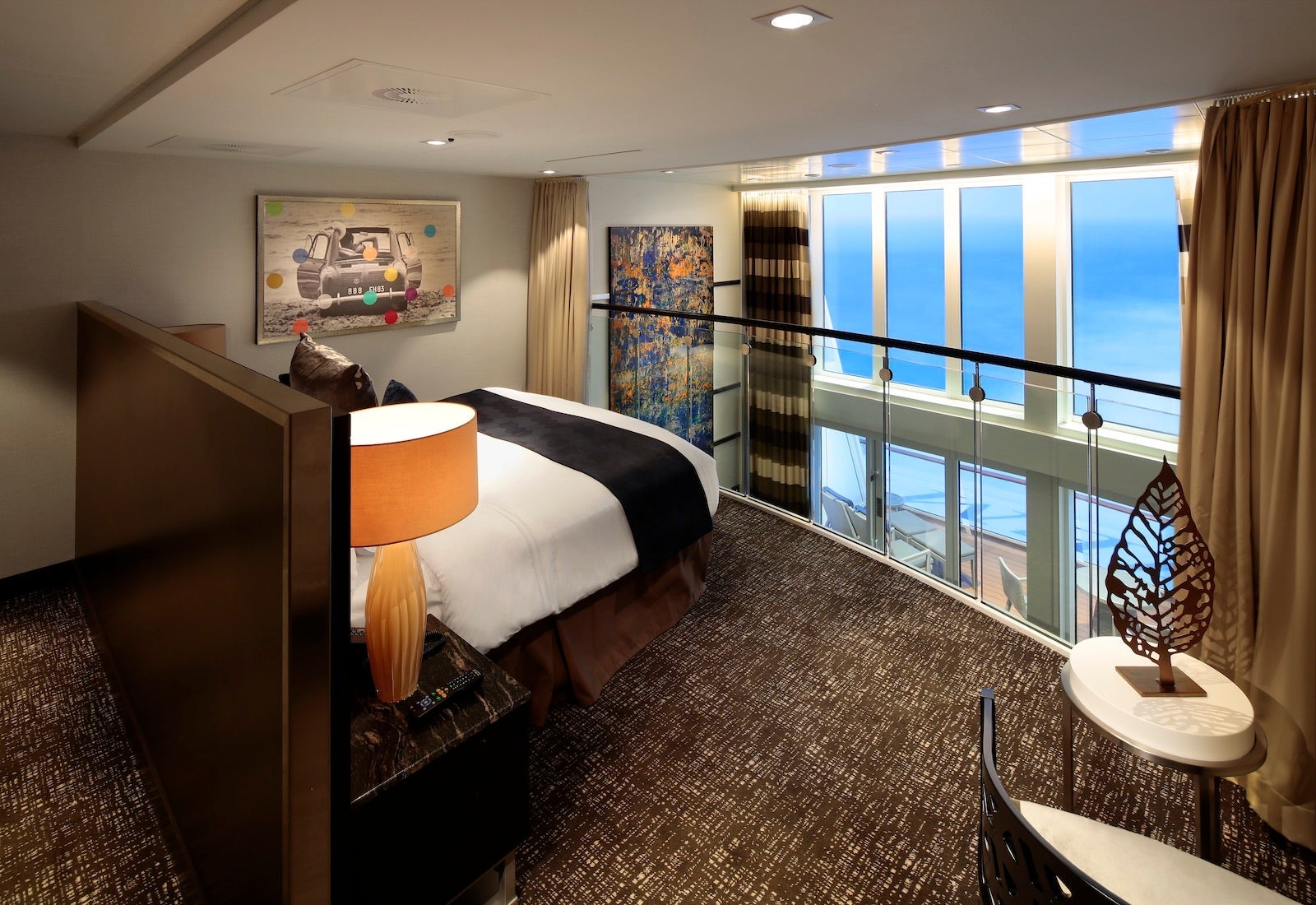 Upstairs bedroom of two-level cruise suite looking out large windows