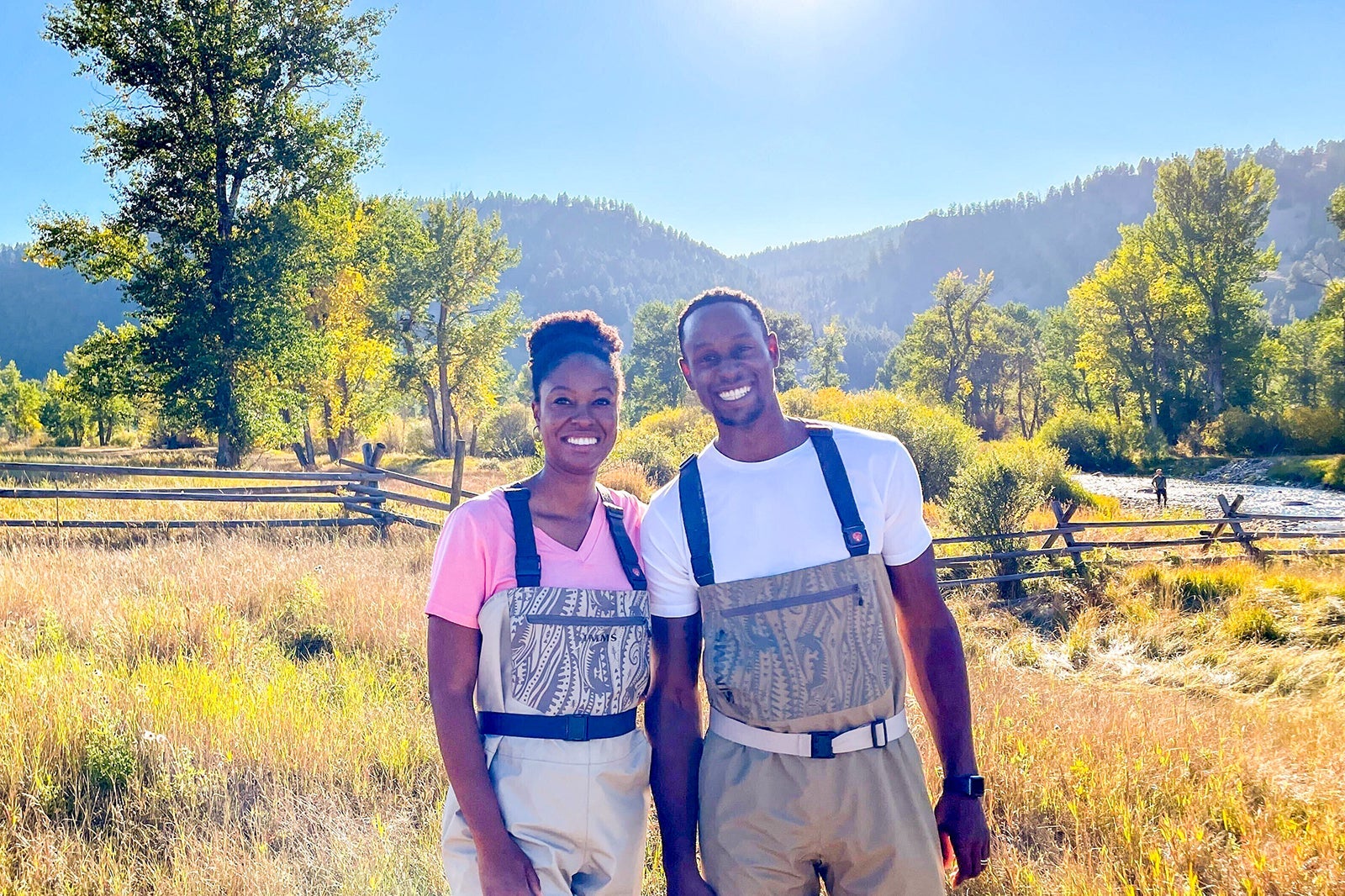 Ashley Onadele and her husband in Montana wearing fly fishing gear.