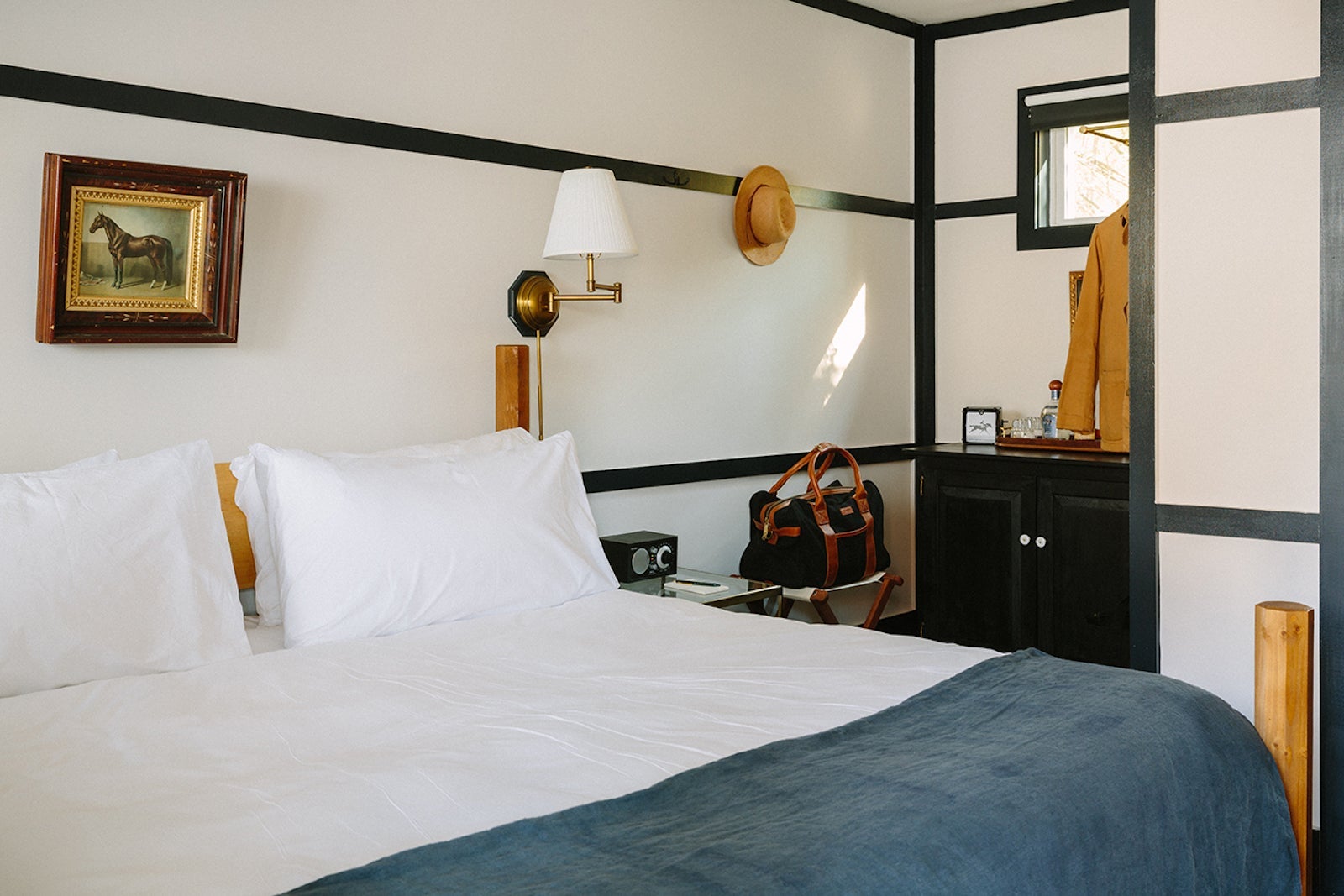 Hotel room with painting of horse and lamp