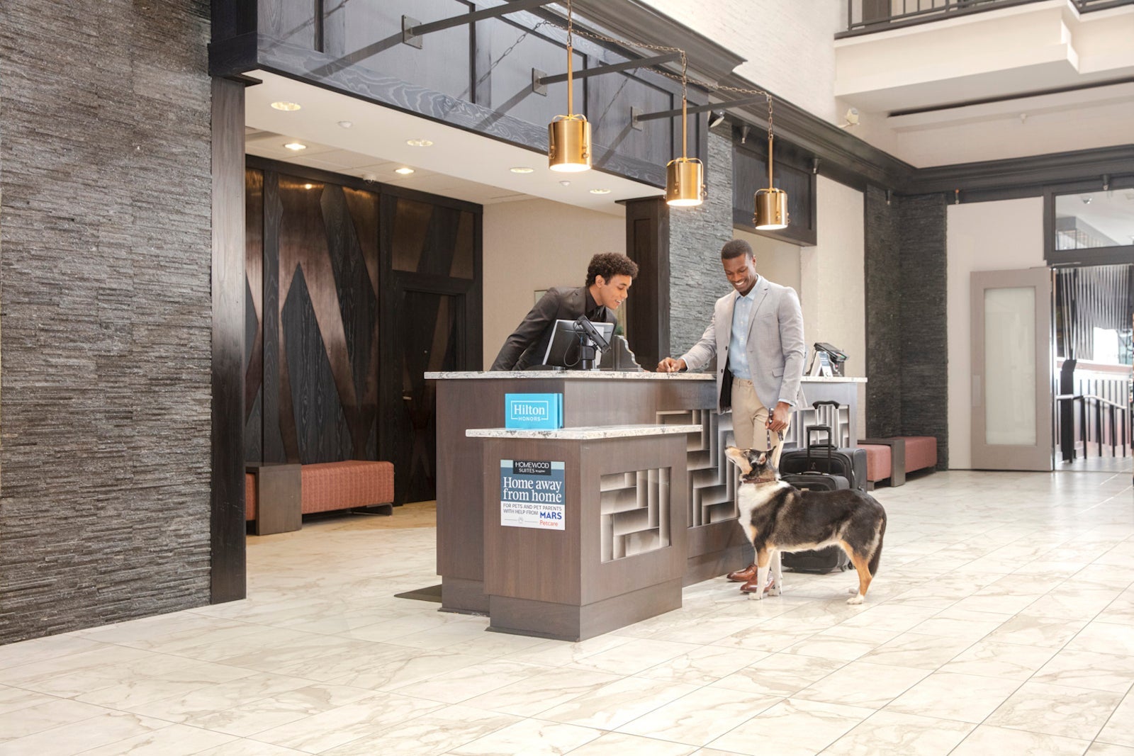 man with dog standing at chieck-in counter of Hilton hotel