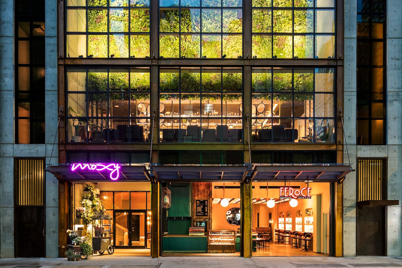entrance to hotel with large windows and second floor bar