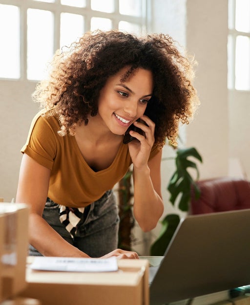 Woman using her cell phone and laptop