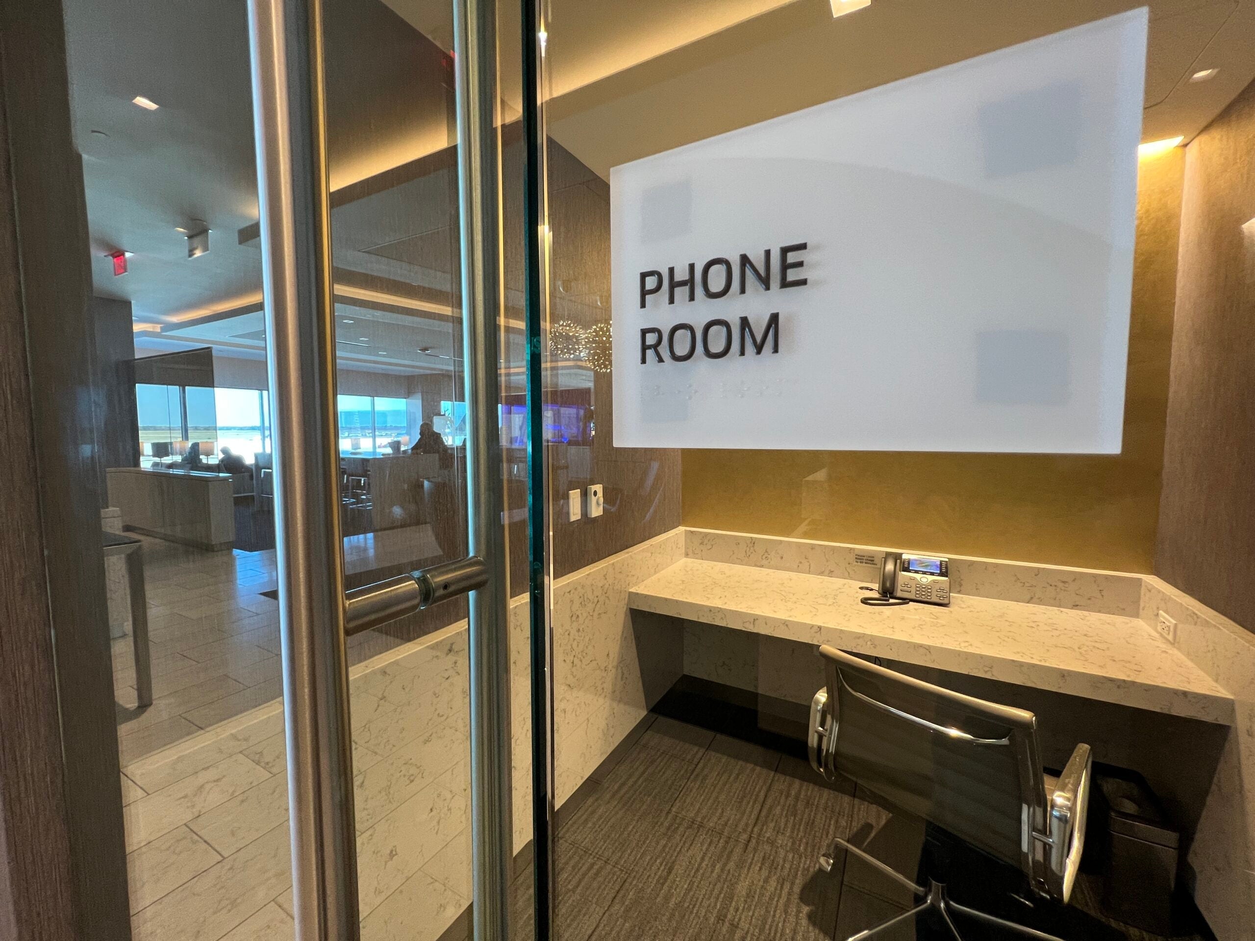 A glass-walled room with a sign that says "phone room"