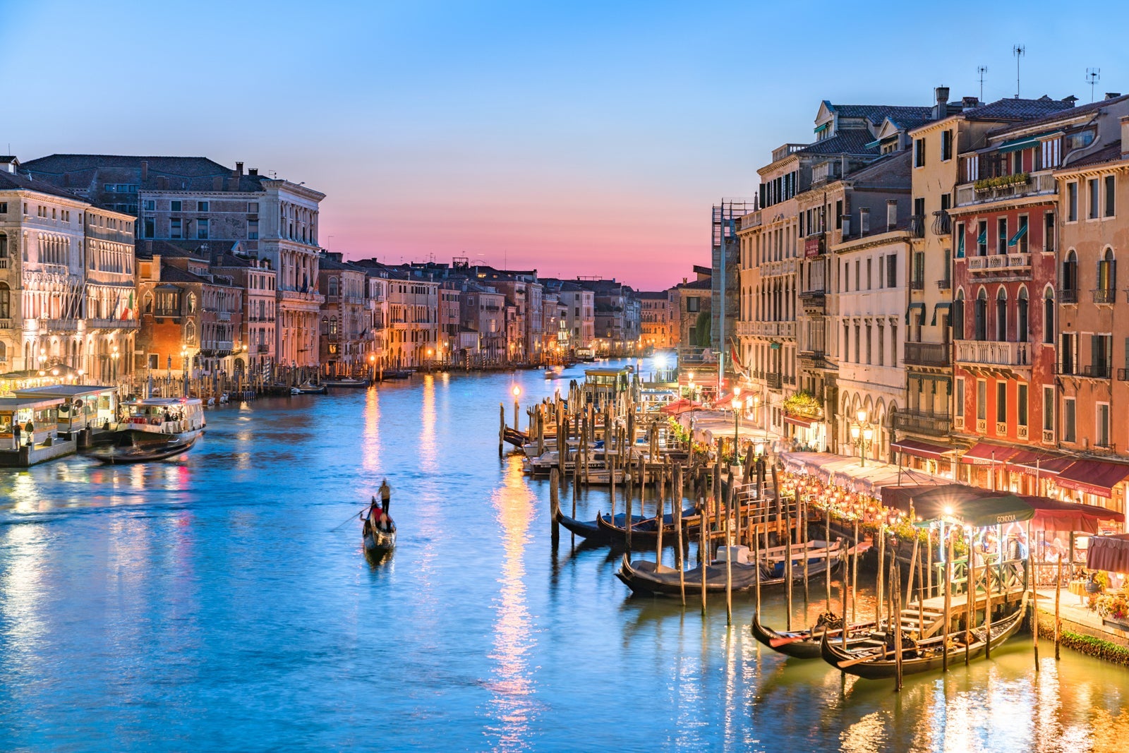 A gondolier heads into Venice's Grand Canal at sunset